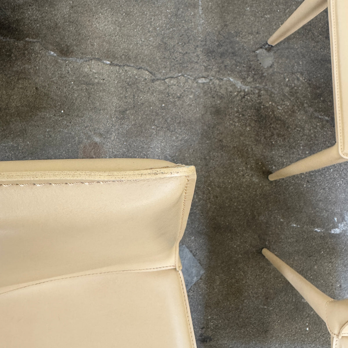 Eight light-tan Frag Bottega leather dining chairs arranged in two rows.