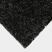 The Kasthall Moss Rug, designed by Gunnila Lagerhem Ullberg, is a hand-tufted rug featuring a shaggy black texture on a crisp white background.