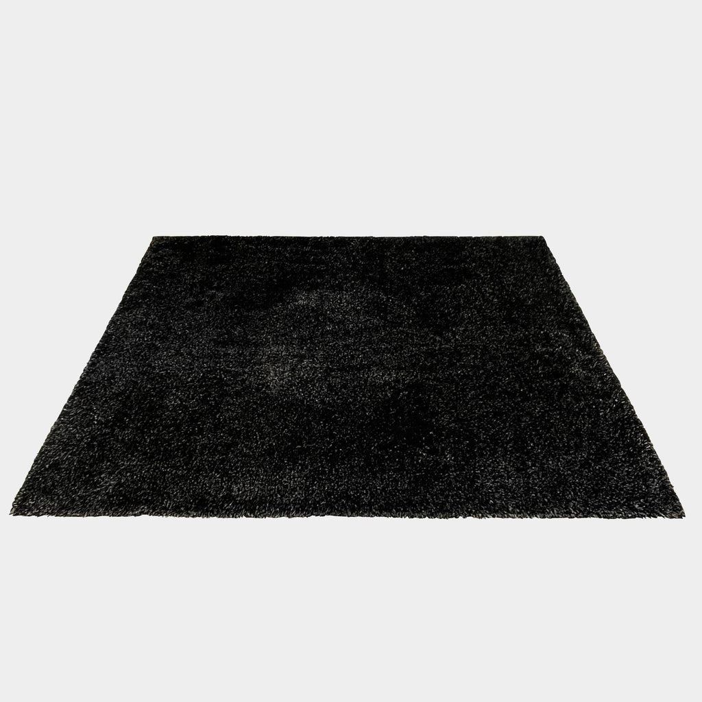 The Kasthall Moss Rug, designed by Gunnila Lagerhem Ullberg, is a hand-tufted rug featuring a shaggy black texture on a crisp white background.