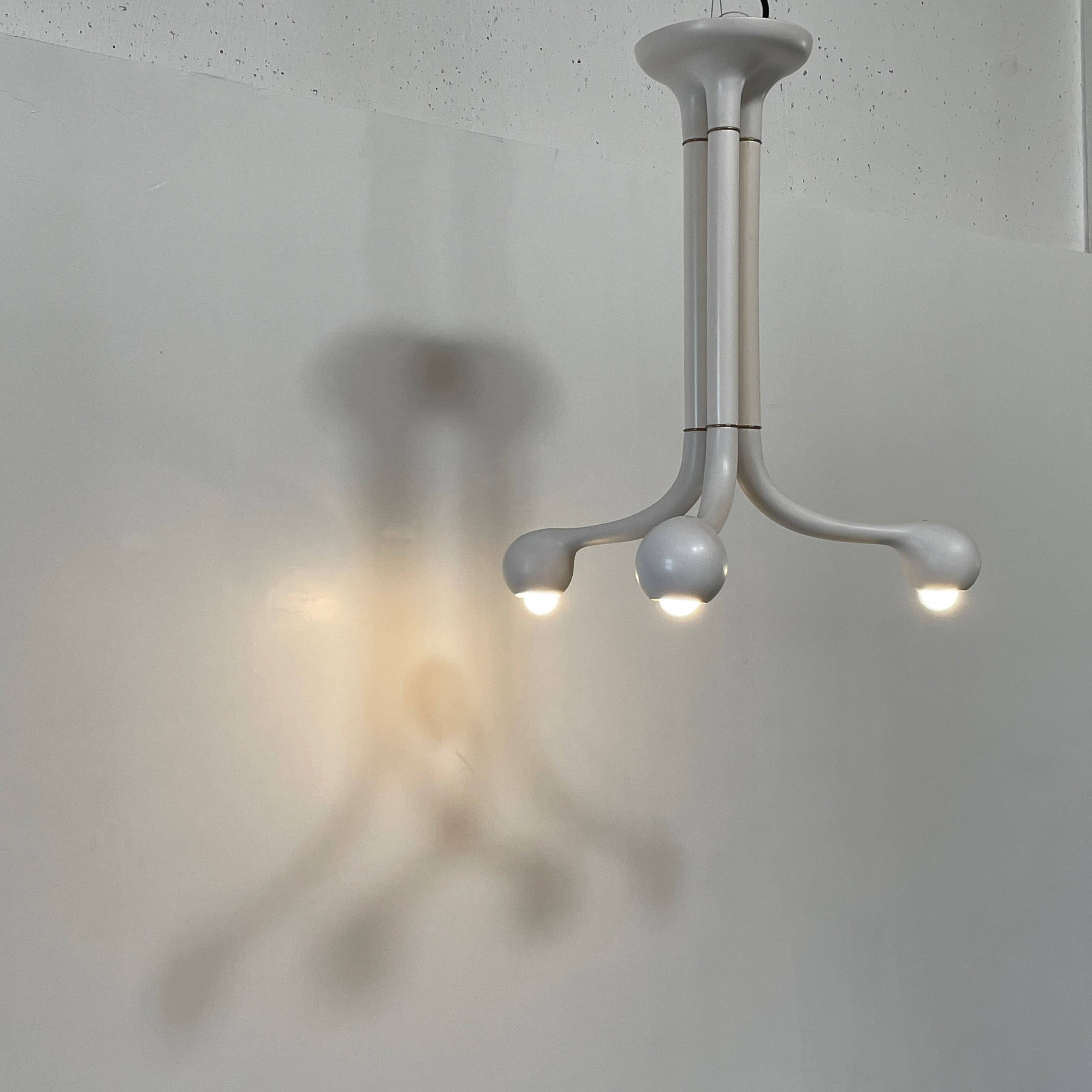 A white, three-legged stand with rounded feet and a flat top against a plain background, reminiscent of the elegant aesthetic found in Entler Studio's 3-Globe Ceiling Light creations.