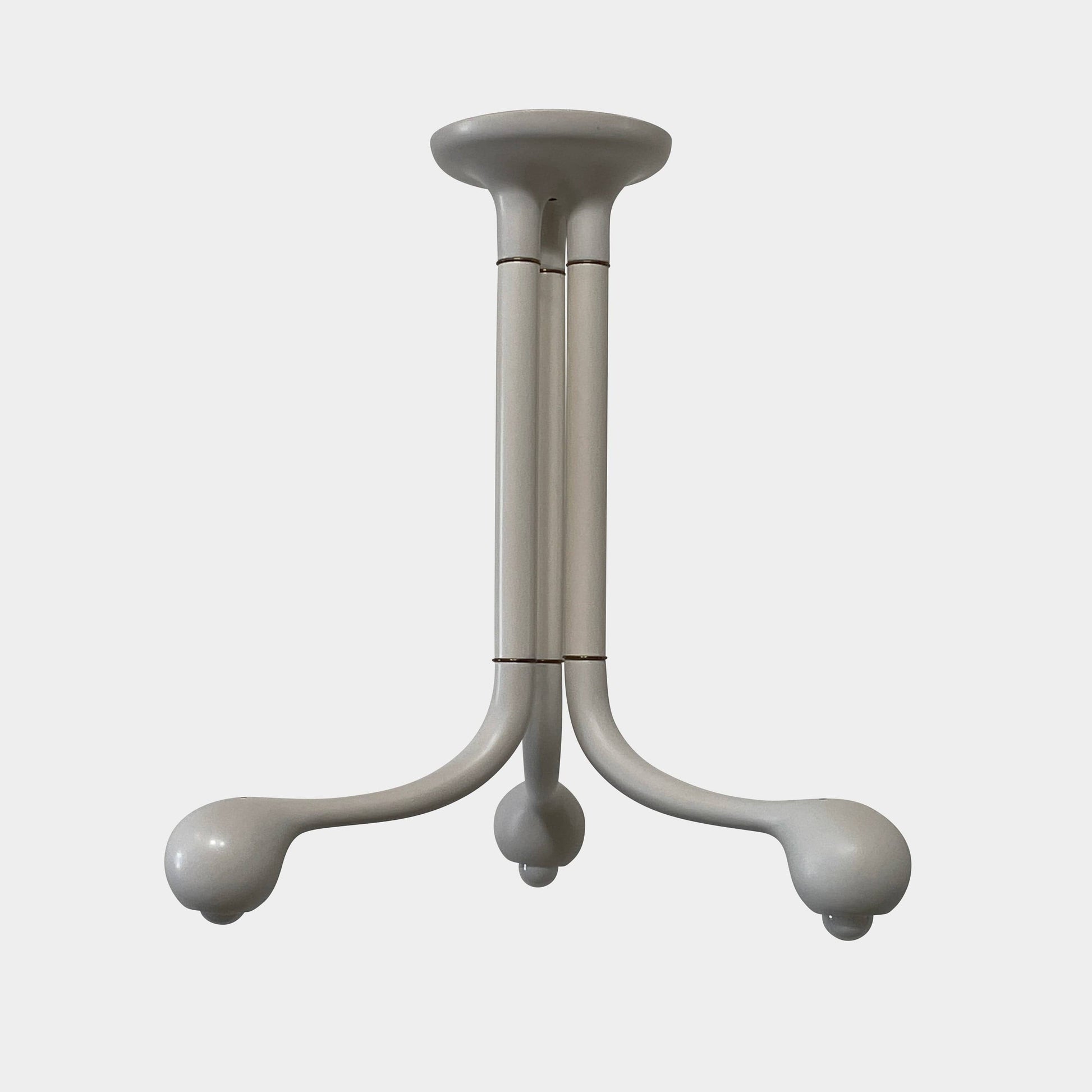 A white, three-legged stand with rounded feet and a flat top against a plain background, reminiscent of the elegant aesthetic found in Entler Studio's 3-Globe Ceiling Light creations.