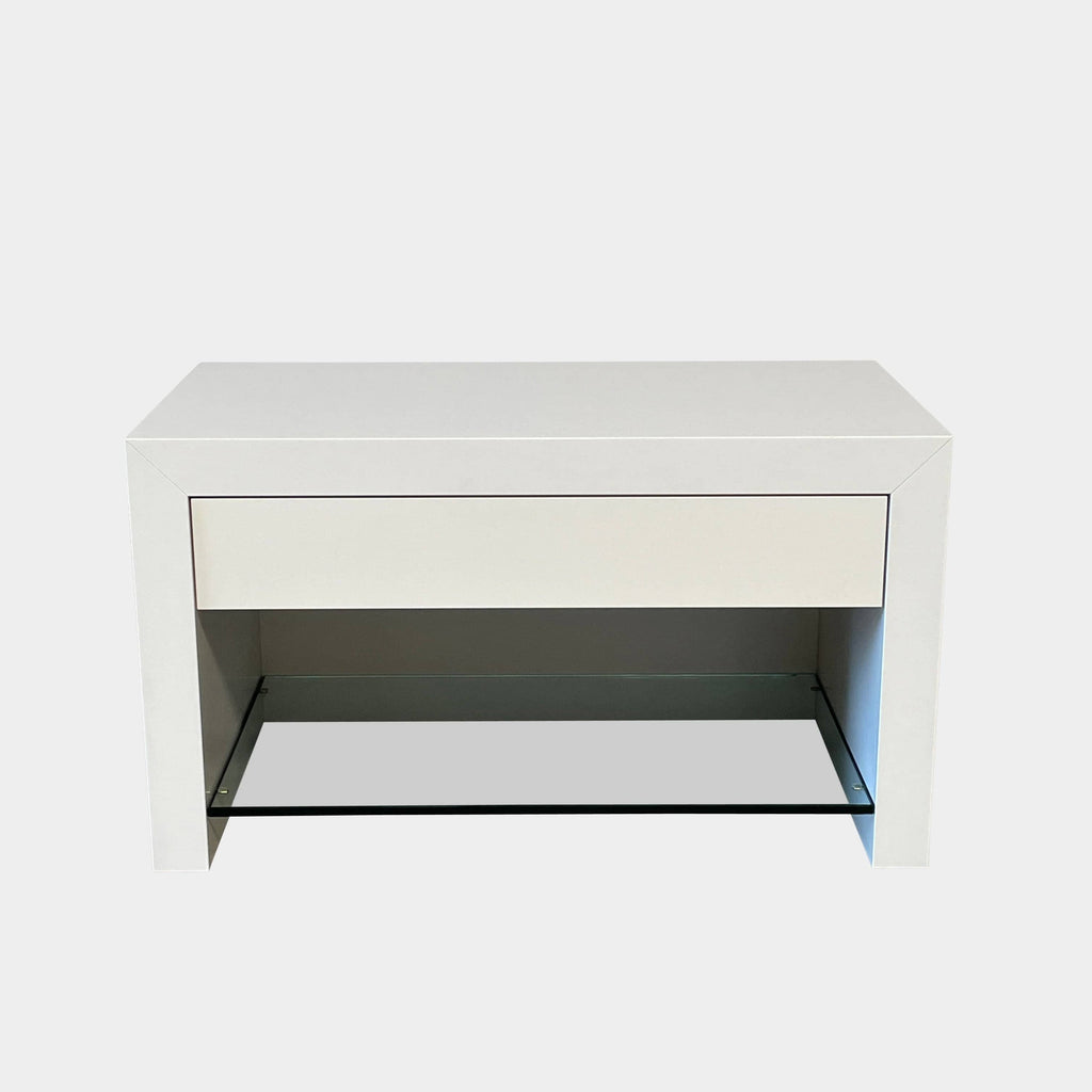 A Ligne Roset Cineline Bedside Table, with a glass top, featuring solid craftsmanship and modern aesthetics.
