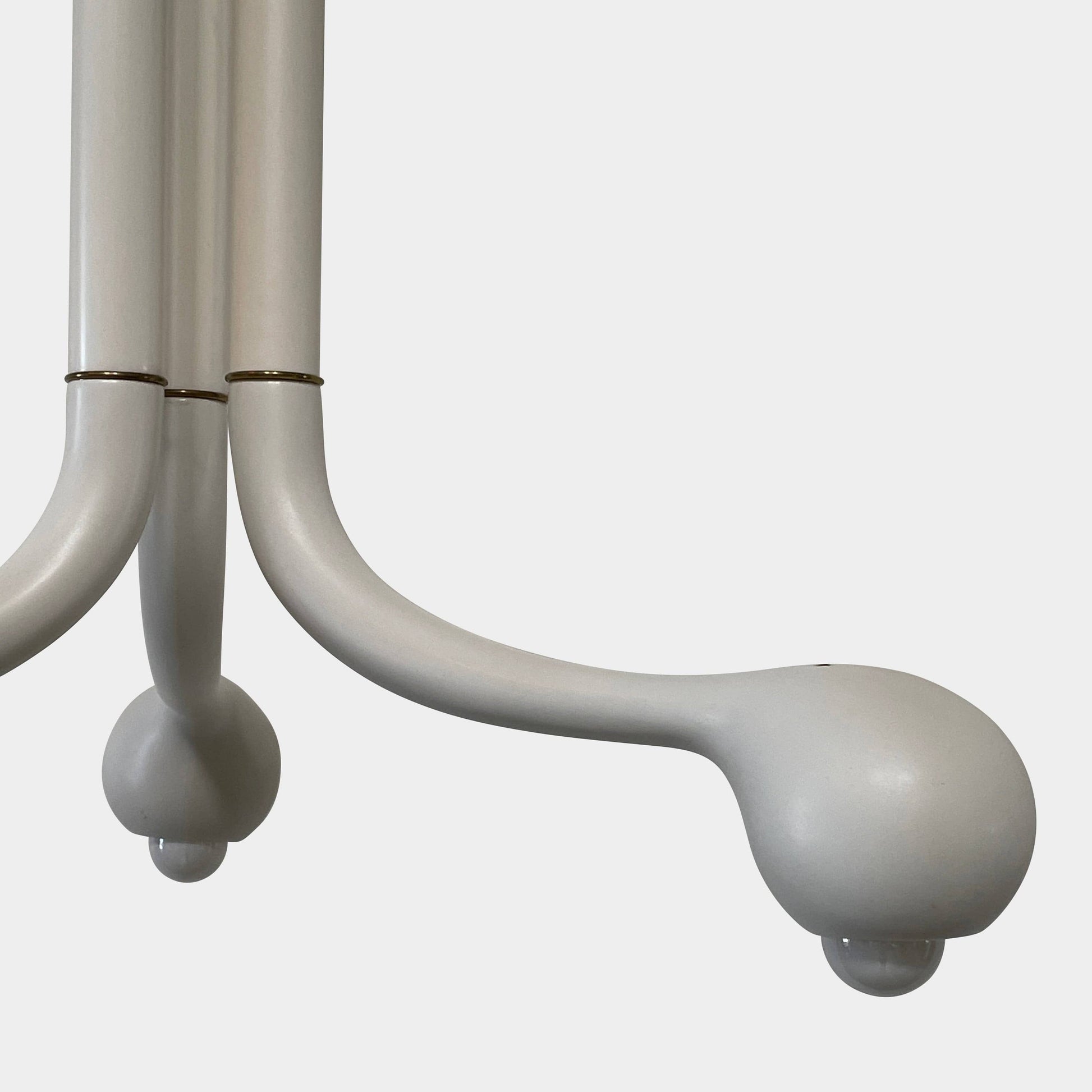 A white, three-legged stand with rounded feet and a flat top against a plain background, reminiscent of the elegant aesthetic found in Entler Studio's 3-Globe Ceiling Light creations.