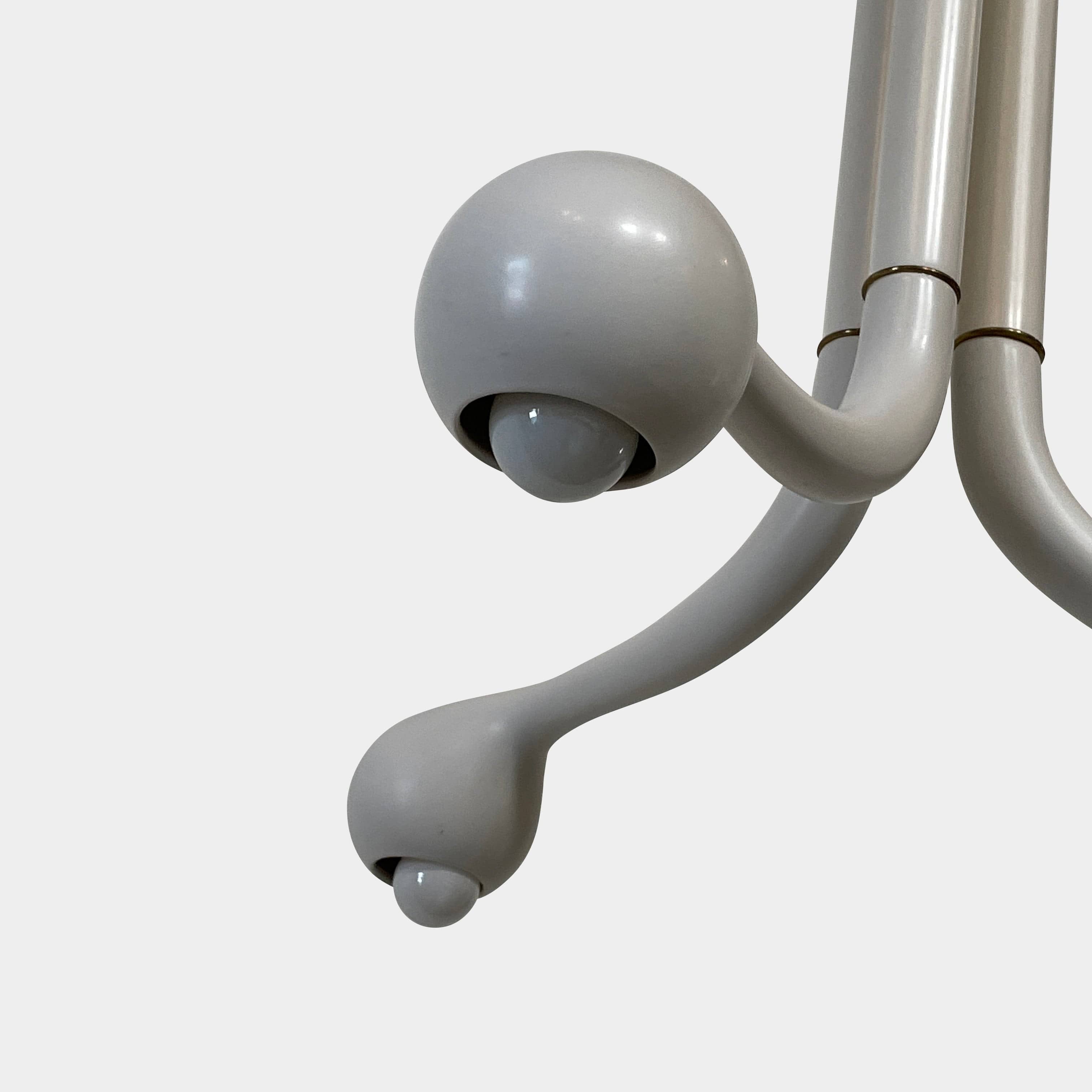 A white, three-legged stand with rounded feet and a flat top against a plain background, reminiscent of the elegant aesthetic found in Entler Studio's 3-Globe Ceiling Light creations.