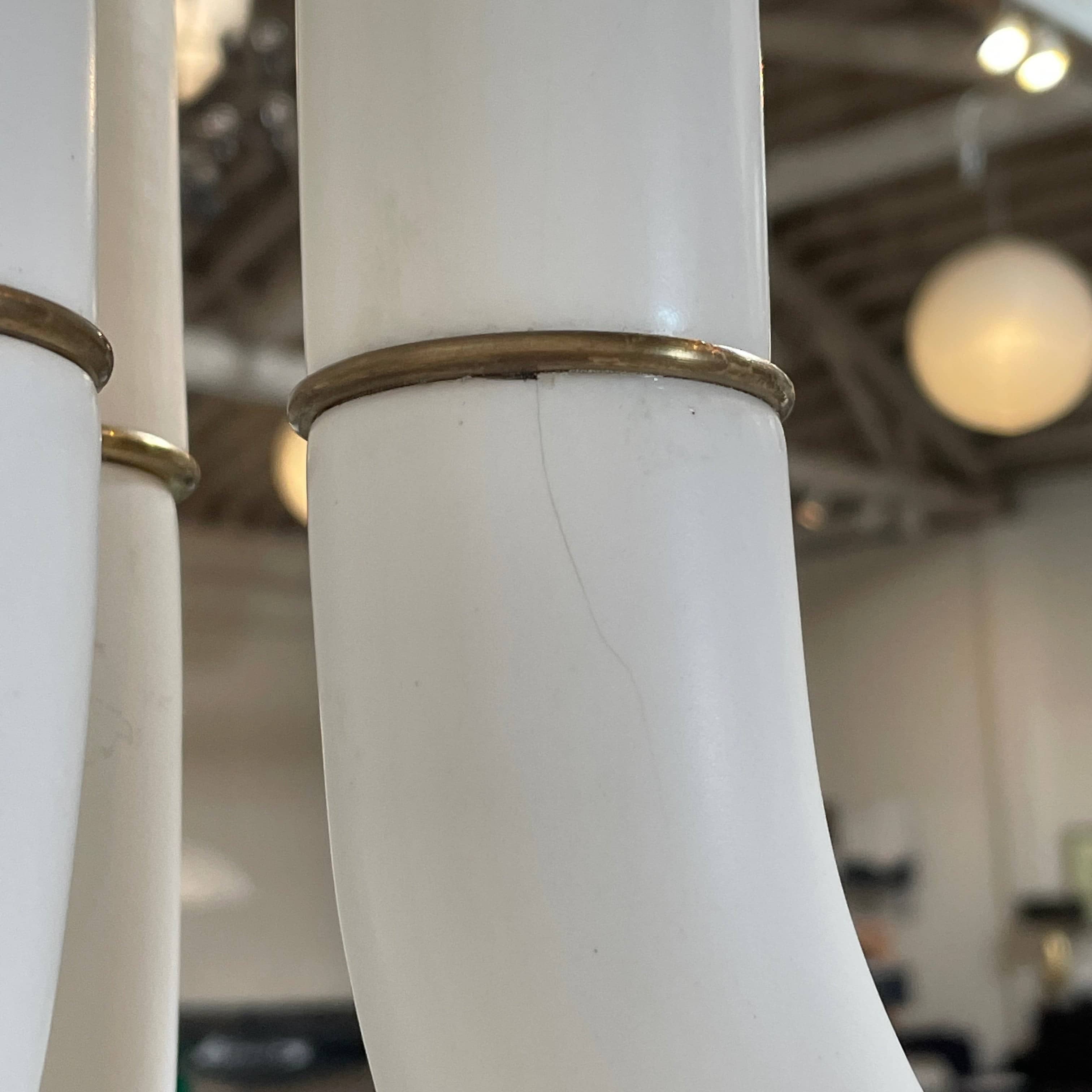 A white, three-legged stand with rounded feet and a flat top against a plain background, reminiscent of the elegant aesthetic found in Entler Studio's 3-Globe Ceiling Light creations.