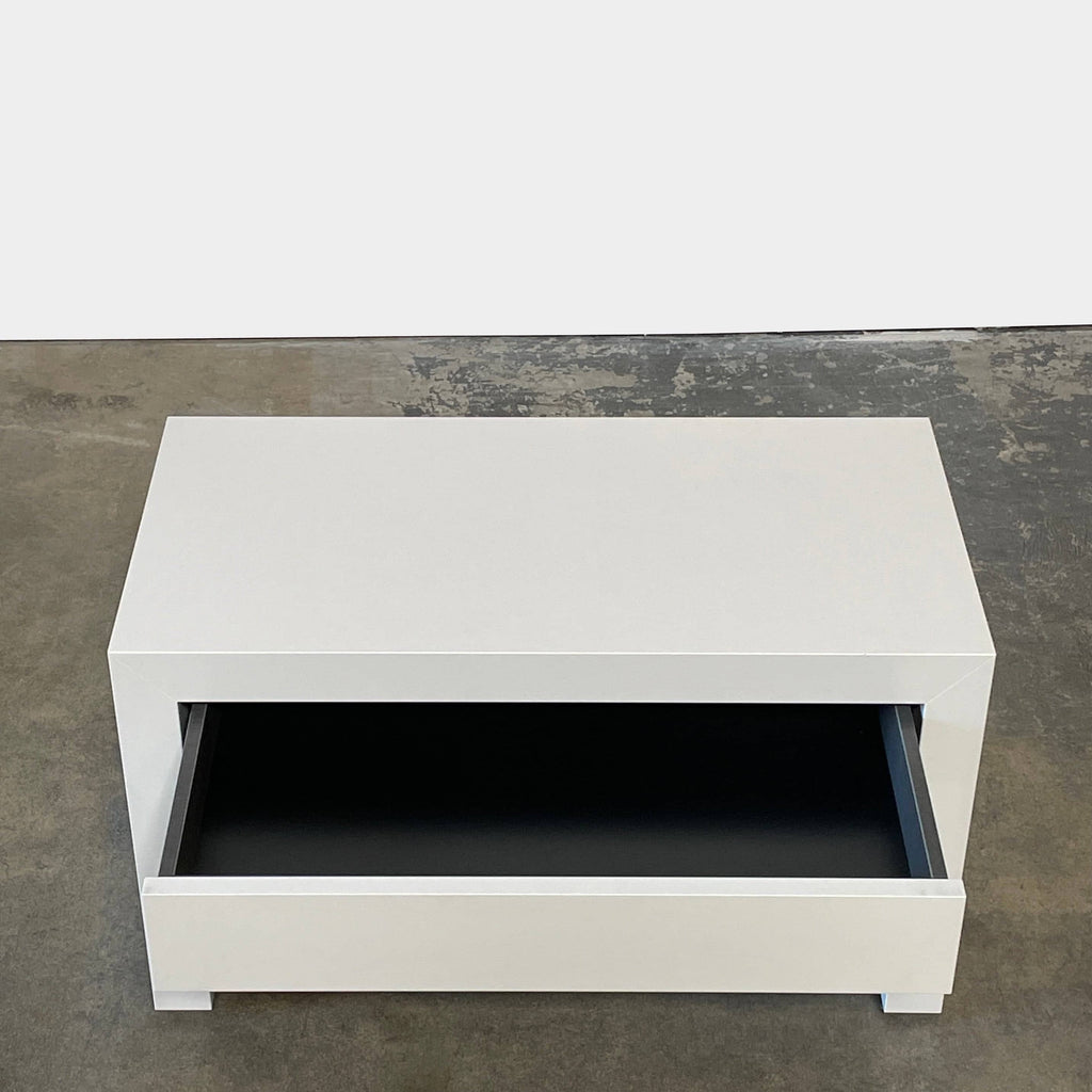 A Ligne Roset Cineline Bedside Table, with a glass top, featuring solid craftsmanship and modern aesthetics.