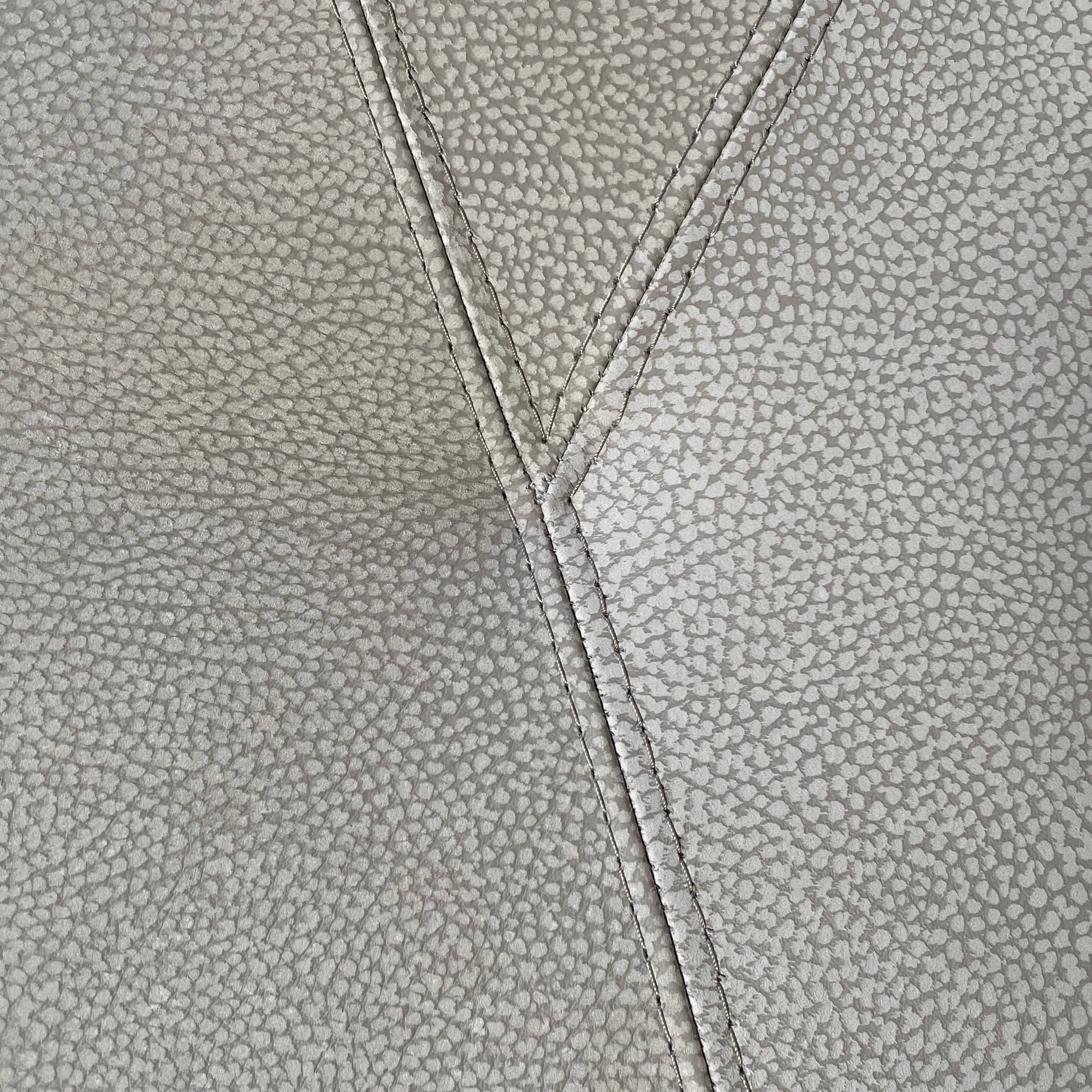 A Roche Bobois Digital Sofa and Ottoman, featuring a curved grey sectional design with three cushions and an additional round ottoman, set against a plain white background.