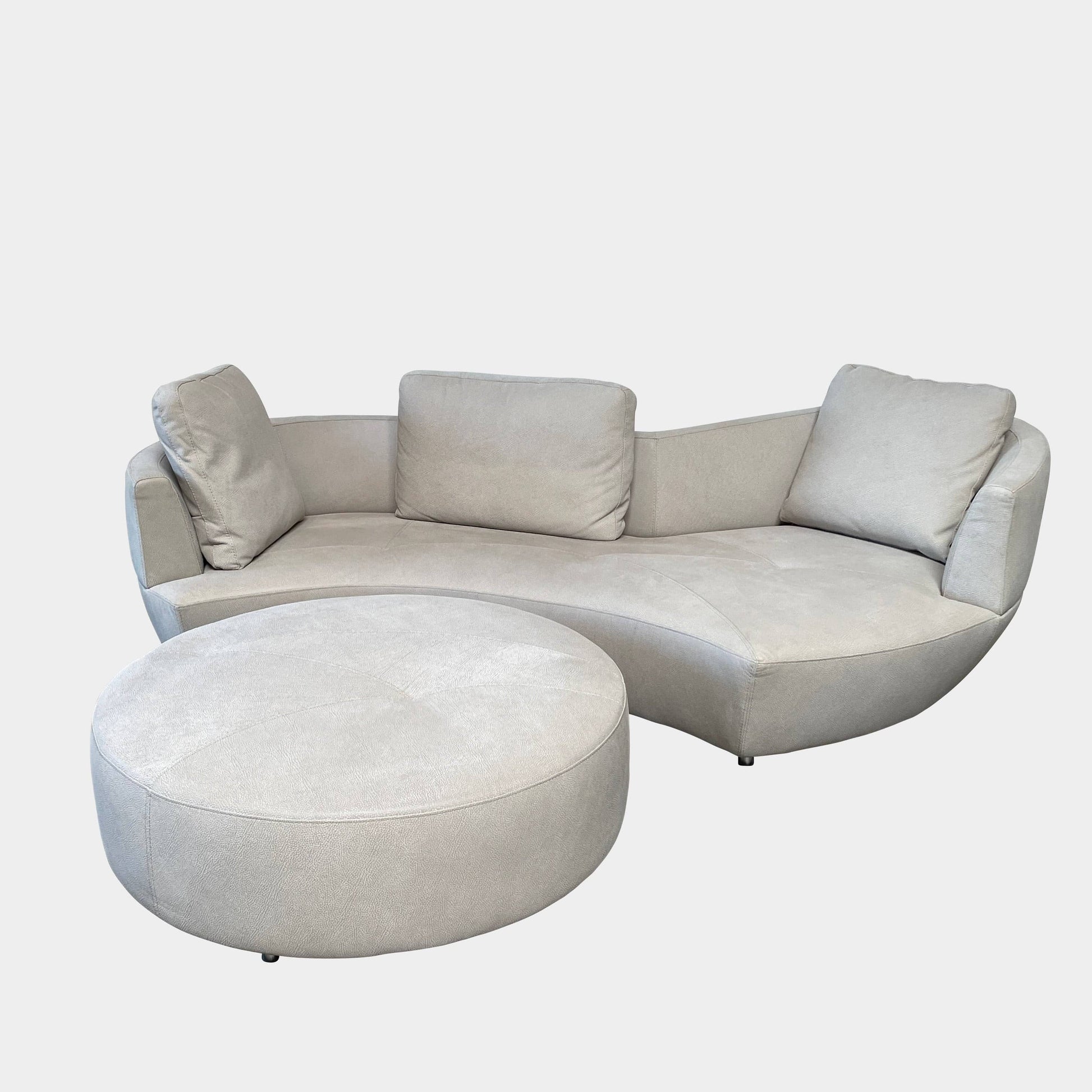 A Roche Bobois Digital Sofa and Ottoman, featuring a curved grey sectional design with three cushions and an additional round ottoman, set against a plain white background.