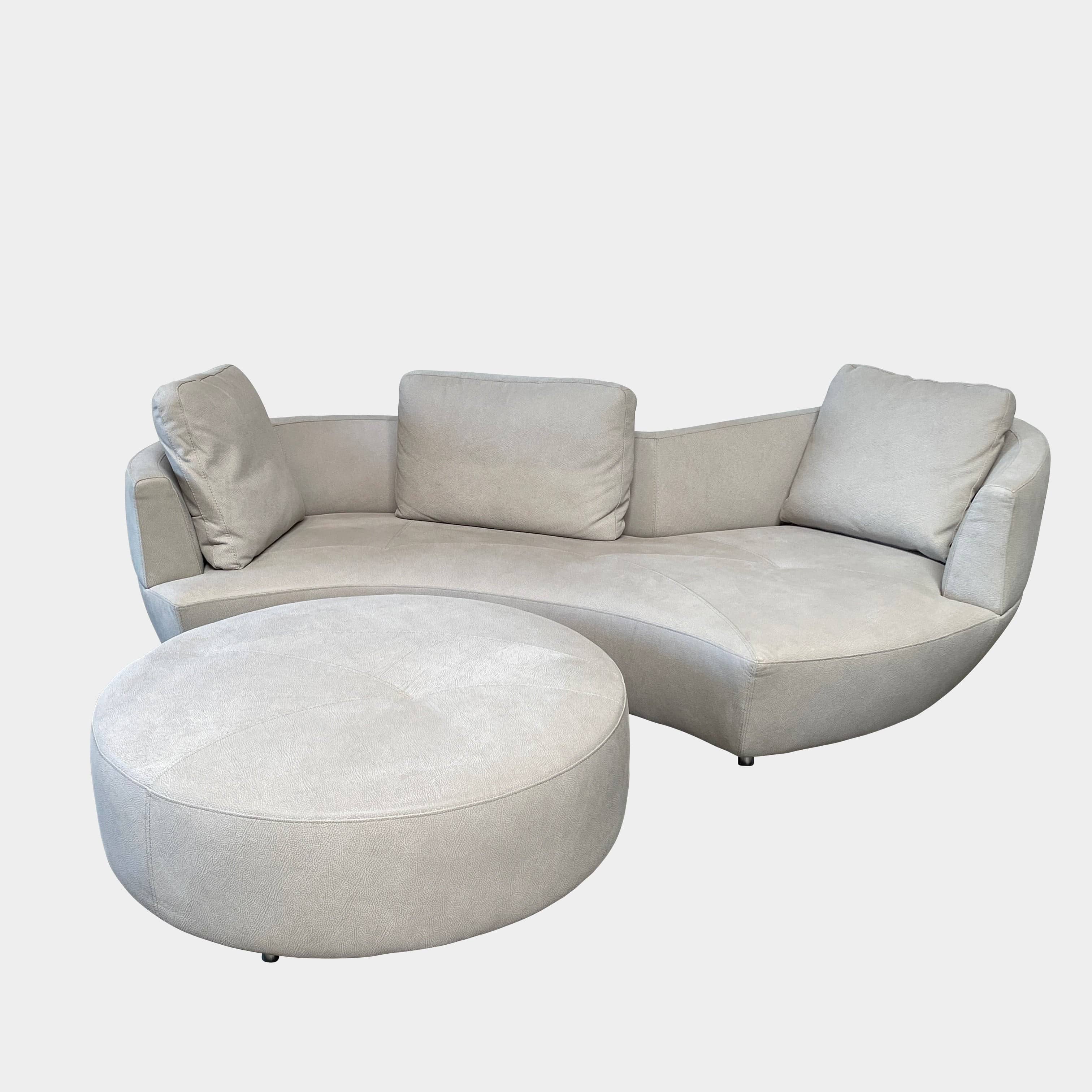 A Roche Bobois Digital Sofa and Ottoman, featuring a curved grey sectional design with three cushions and an additional round ottoman, set against a plain white background.