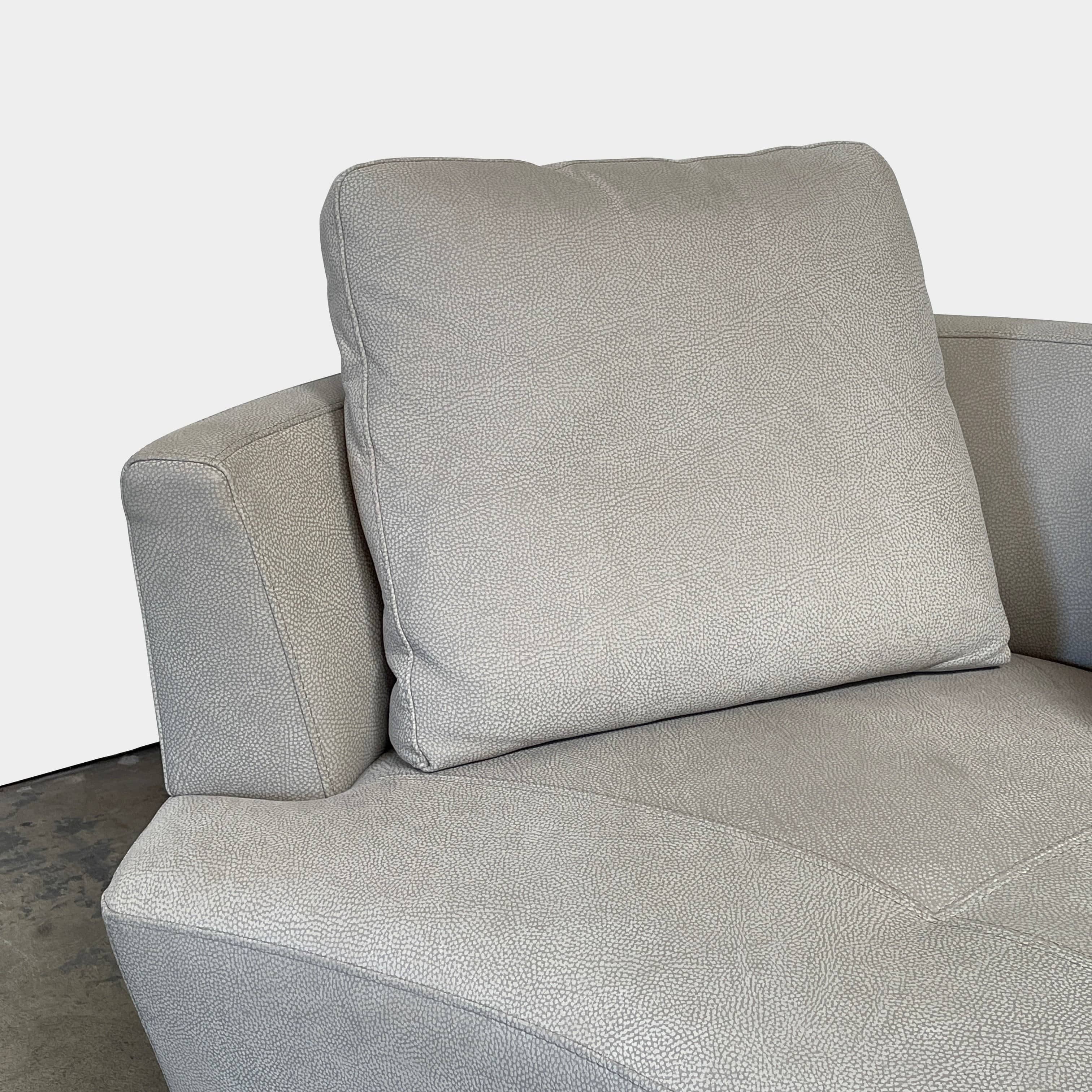 A Roche Bobois Digital Sofa and Ottoman, featuring a curved grey sectional design with three cushions and an additional round ottoman, set against a plain white background.