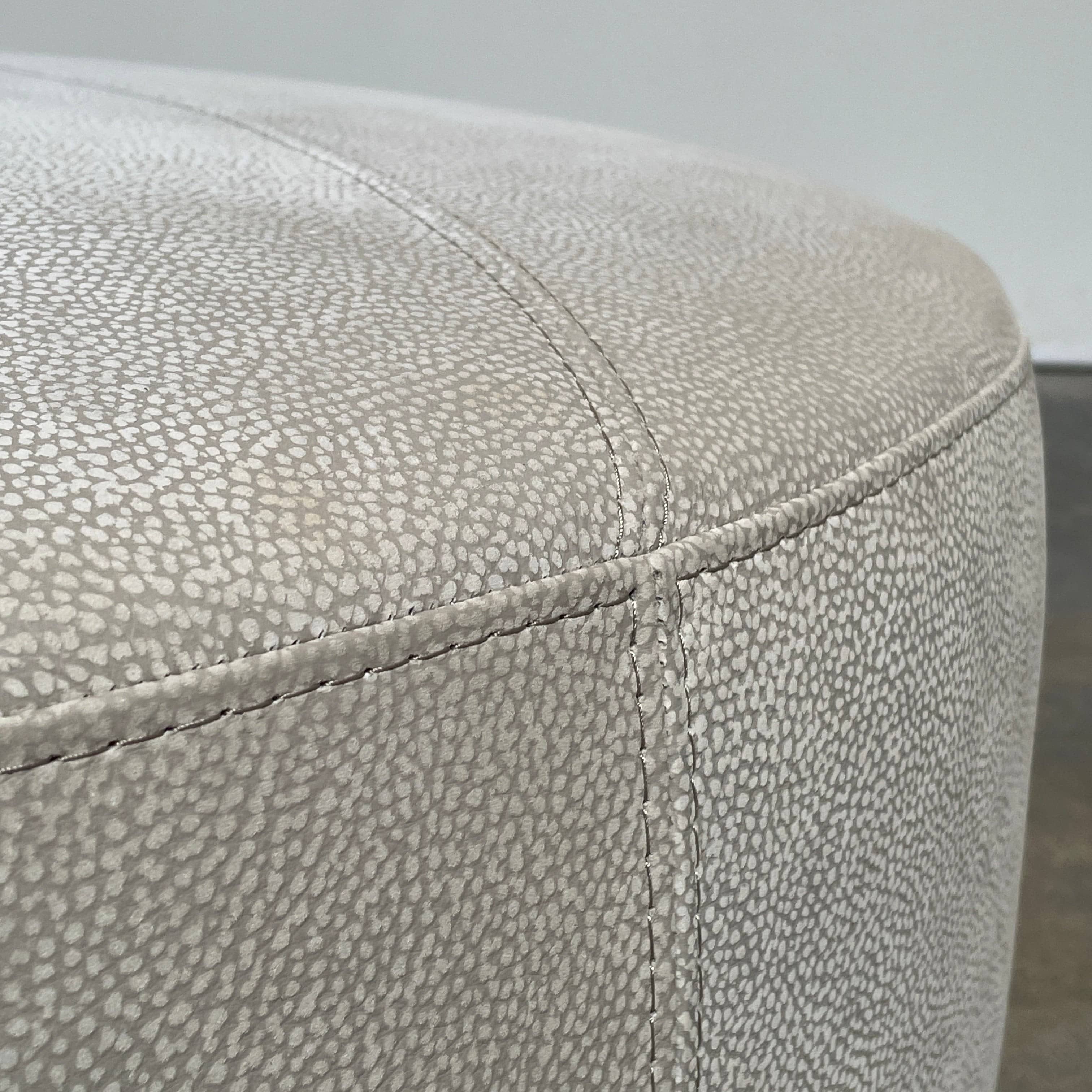 A Roche Bobois Digital Sofa and Ottoman, featuring a curved grey sectional design with three cushions and an additional round ottoman, set against a plain white background.