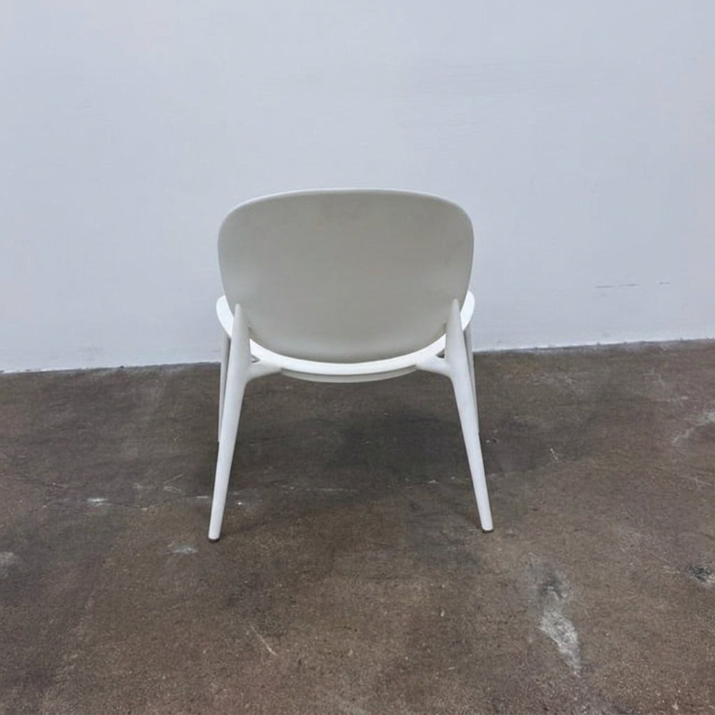 A white Kartell Be Bop lounge chair with a rounded backrest, tapered legs, and a weatherproof design for indoor or outdoor seating.
