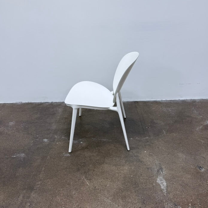 A white Kartell Be Bop lounge chair with a rounded backrest, tapered legs, and a weatherproof design for indoor or outdoor seating.