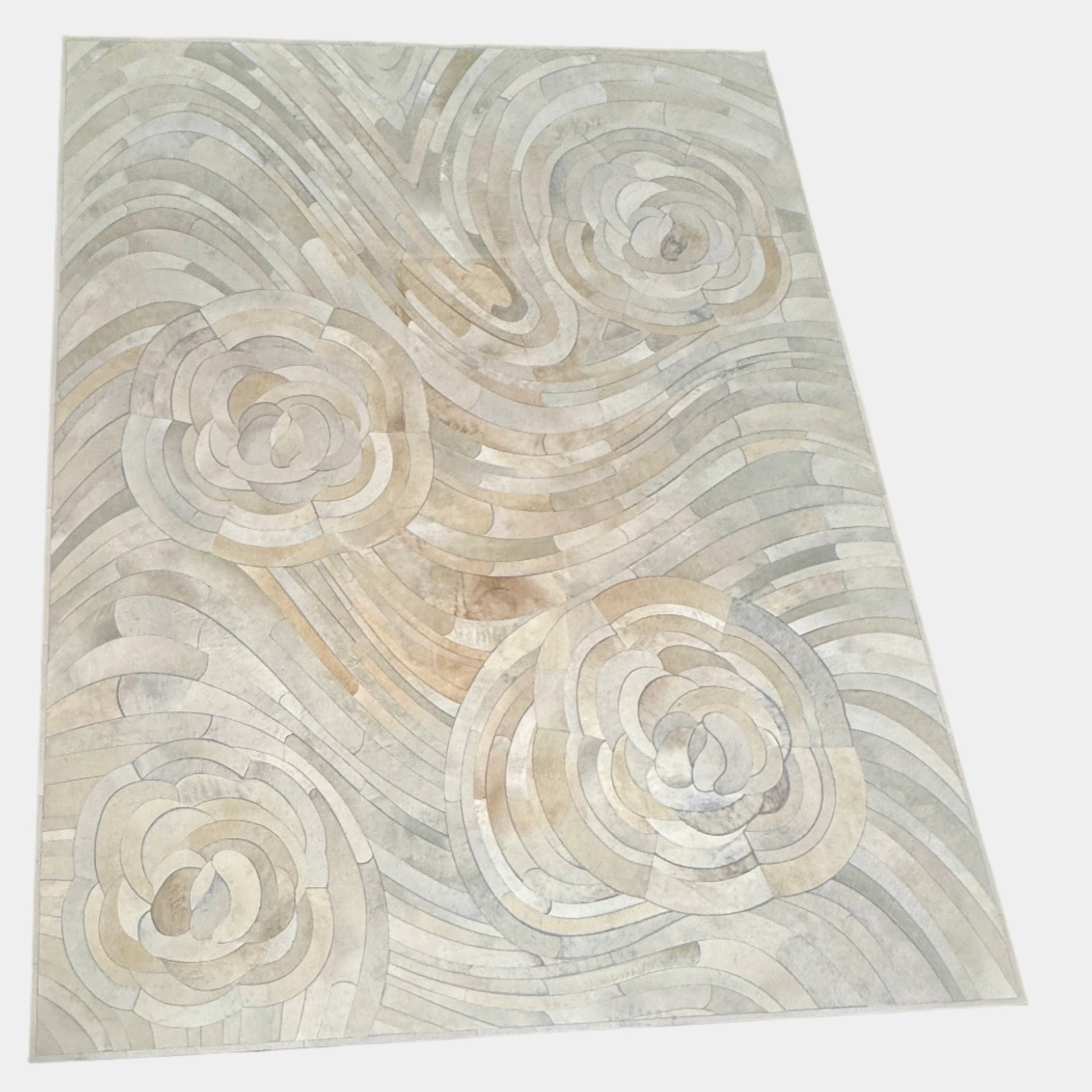 The Kyle Bunting Hide Rug - Drift by Kyle Bunting features a rectangular form with wavy, swirling abstract patterns in beige, cream, and light gray, accented by circular, flower-like designs that highlight exquisite craftsmanship.