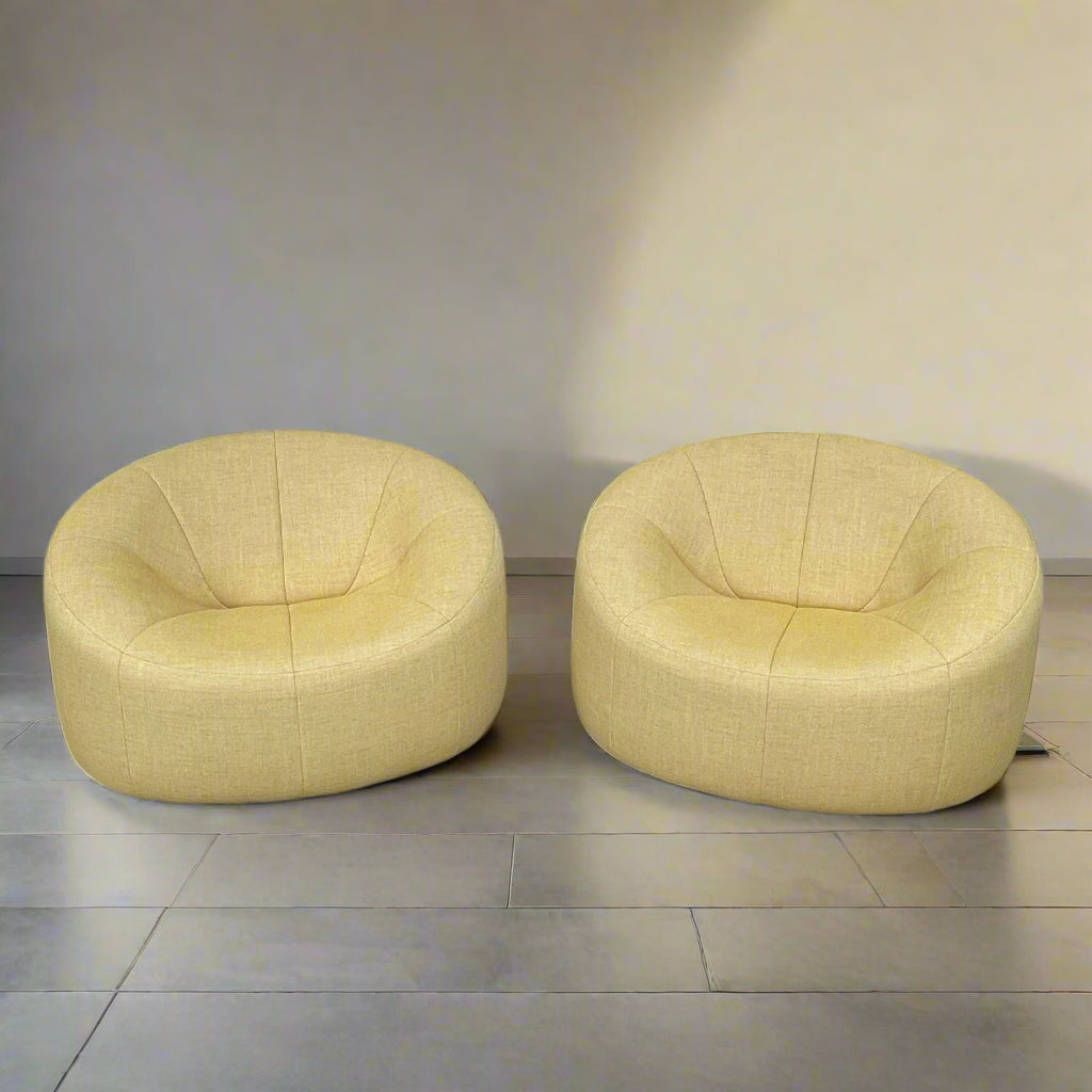 A light yellow Ligne Roset Pumpkin Swivel Lounge Chair with a round shape, low back, and wide seat is shown against a plain white background.