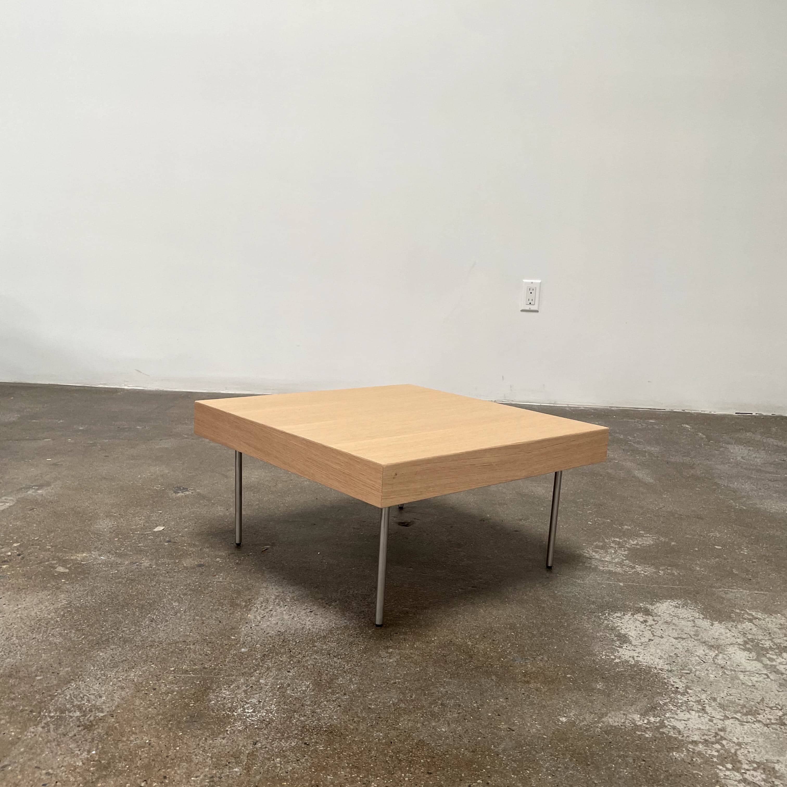 Ligne Roset Natural Wood Needle Table with metal legs on a plain white background, showcasing an elegant natural design.