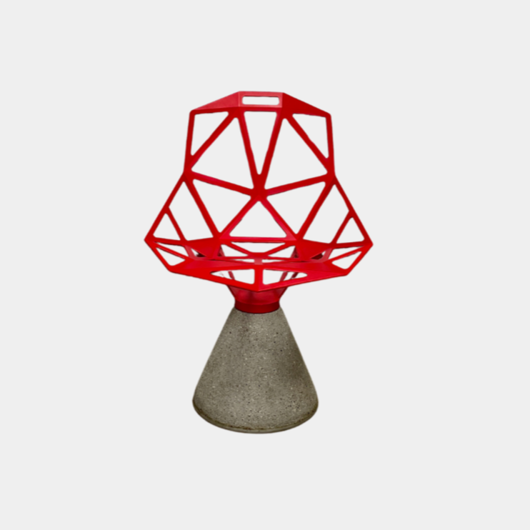 A Magis Red Chair One with a swivel base is positioned on a concrete foundation against a plain white background, reflecting the innovative style of Konstantin Grcic's designs.