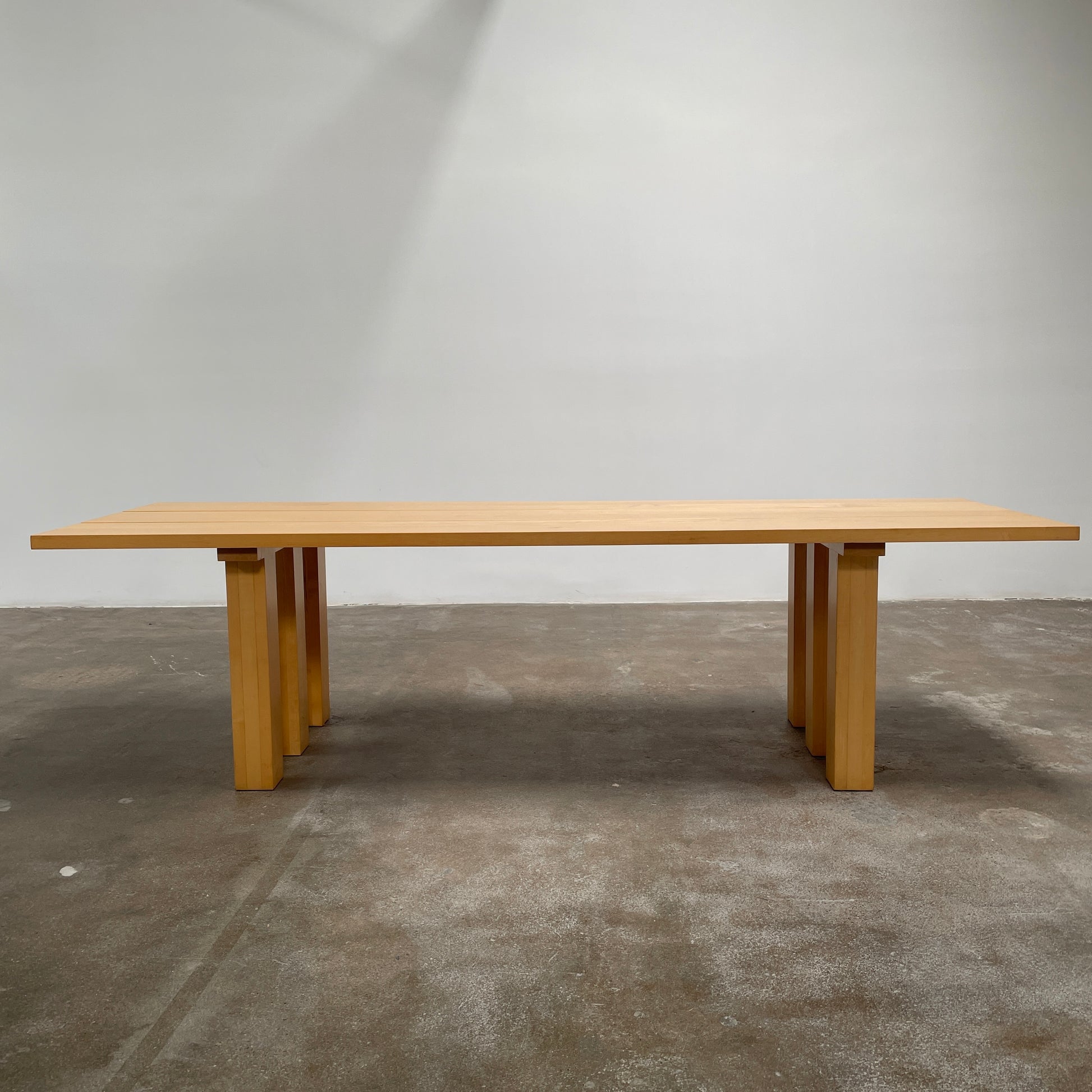 A Vintage Cassina La Basilica Dining Table by Mario Bellini, featuring a wooden rectangular design with a simple aesthetic and four legs, evocative of the iconic architectural style.