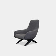 The Poliform Marlon Armchair, featuring a gray finish and sleek, angled wooden legs, exudes modern sophistication against a plain white background.