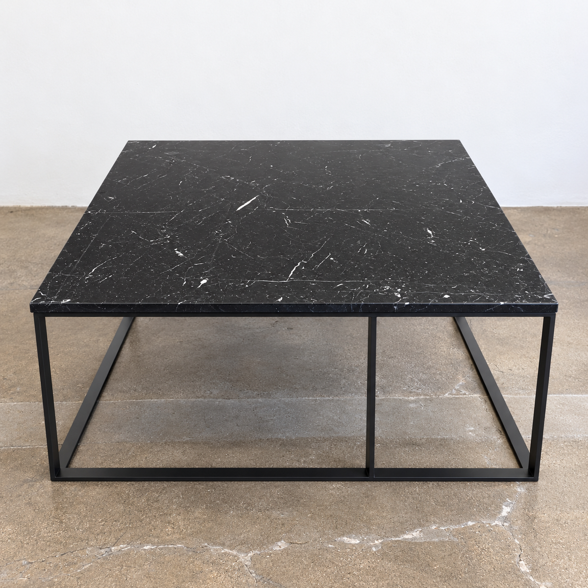 Square Maxalto Lithos coffee table with a black marble top and a black metal frame.