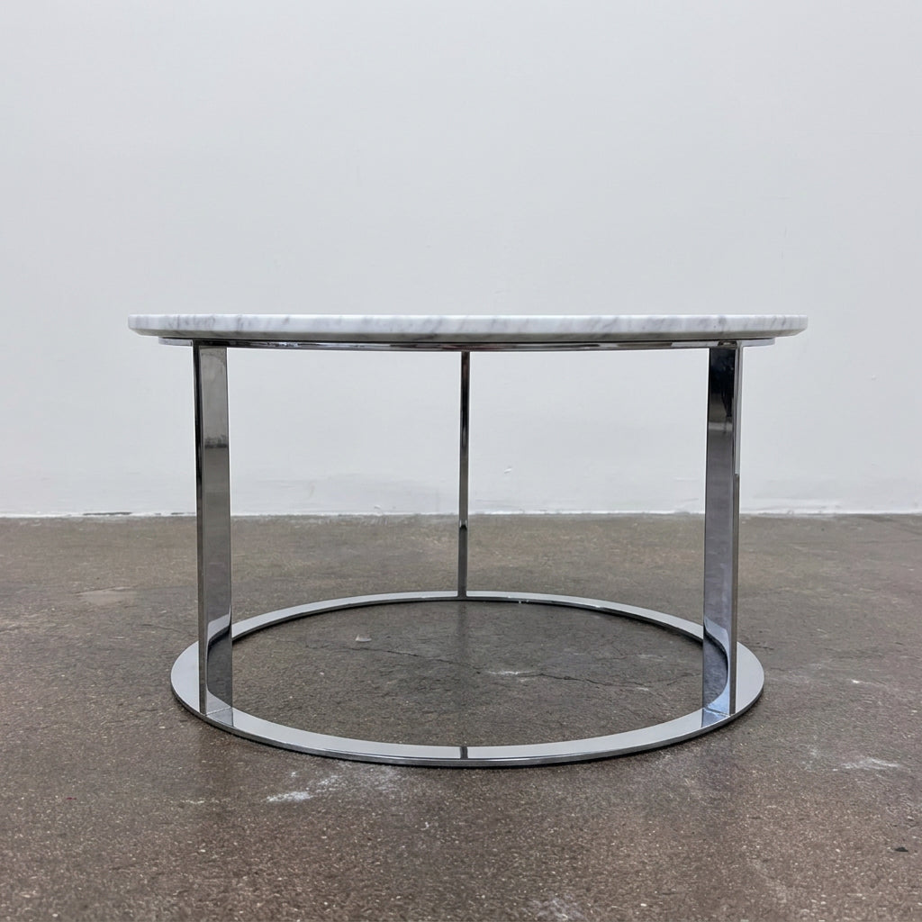 B&B Italia Mera Round Coffee Table with a white Carrara marble top and a dark metal circular base.