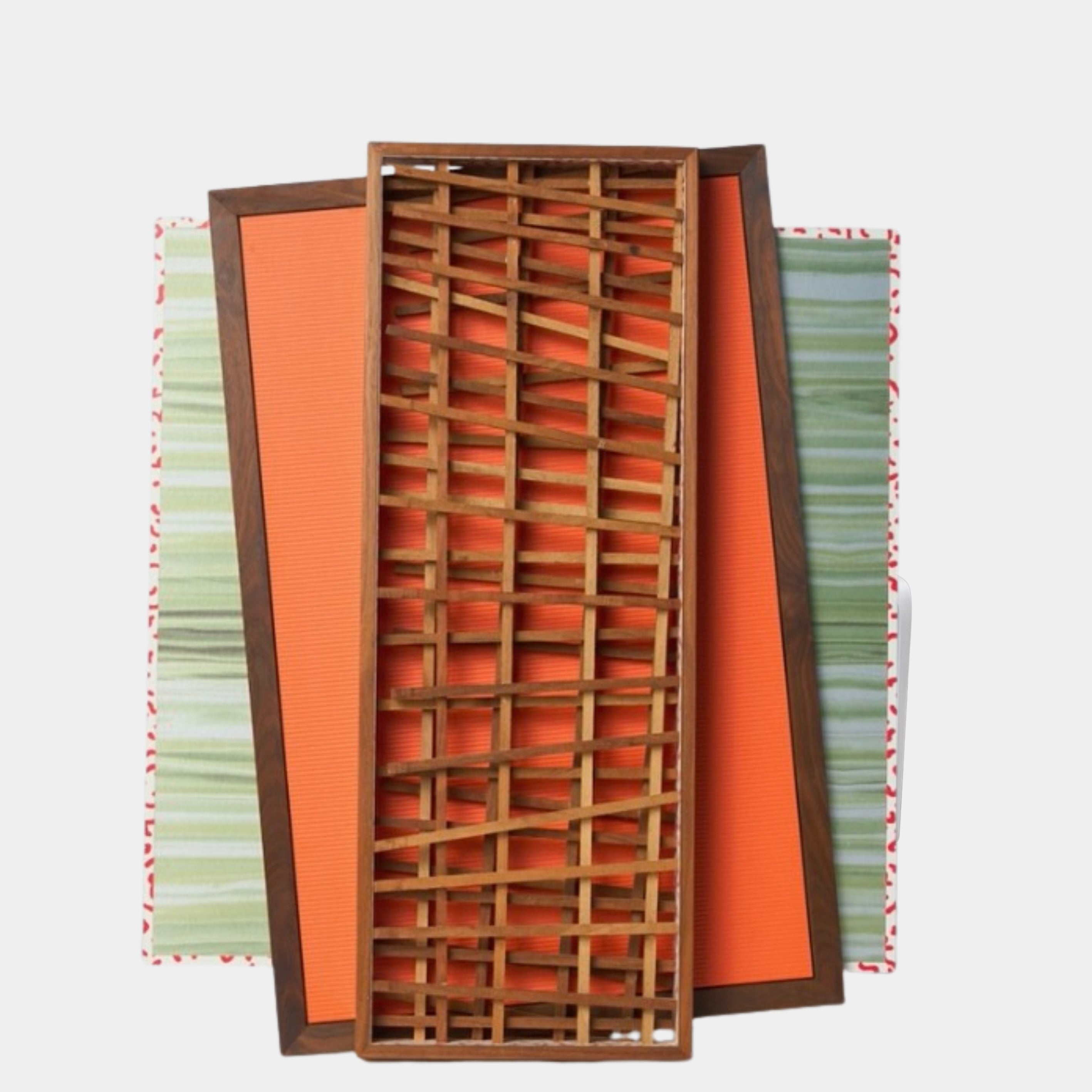 Three rectangular trays—one with green stripes, one orange, and one wooden tray with a lattice design—overlap to form the “Multi Media Wall Art: by Mike Fair” by Artist, evoking the dynamic, layered style characteristic of Mike Fair’s signature 3D wall pieces.