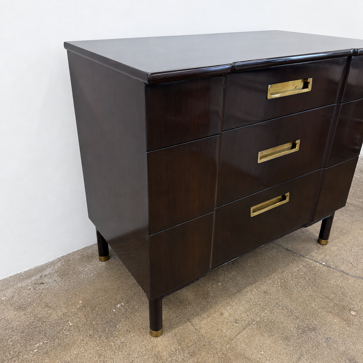 Vintage John Widdicomb Three Drawer Chest in dark wood, featuring three drawers with rectangular brass pulls and tapered legs.