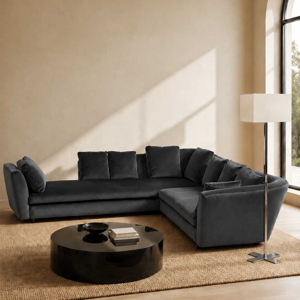 A contemporary Minotti Seymour Sofa, featuring a grey L-shaped design inspired by architectural forms, includes five matching back cushions and one side cushion, all upholstered in fabric and presented against a plain white background.
