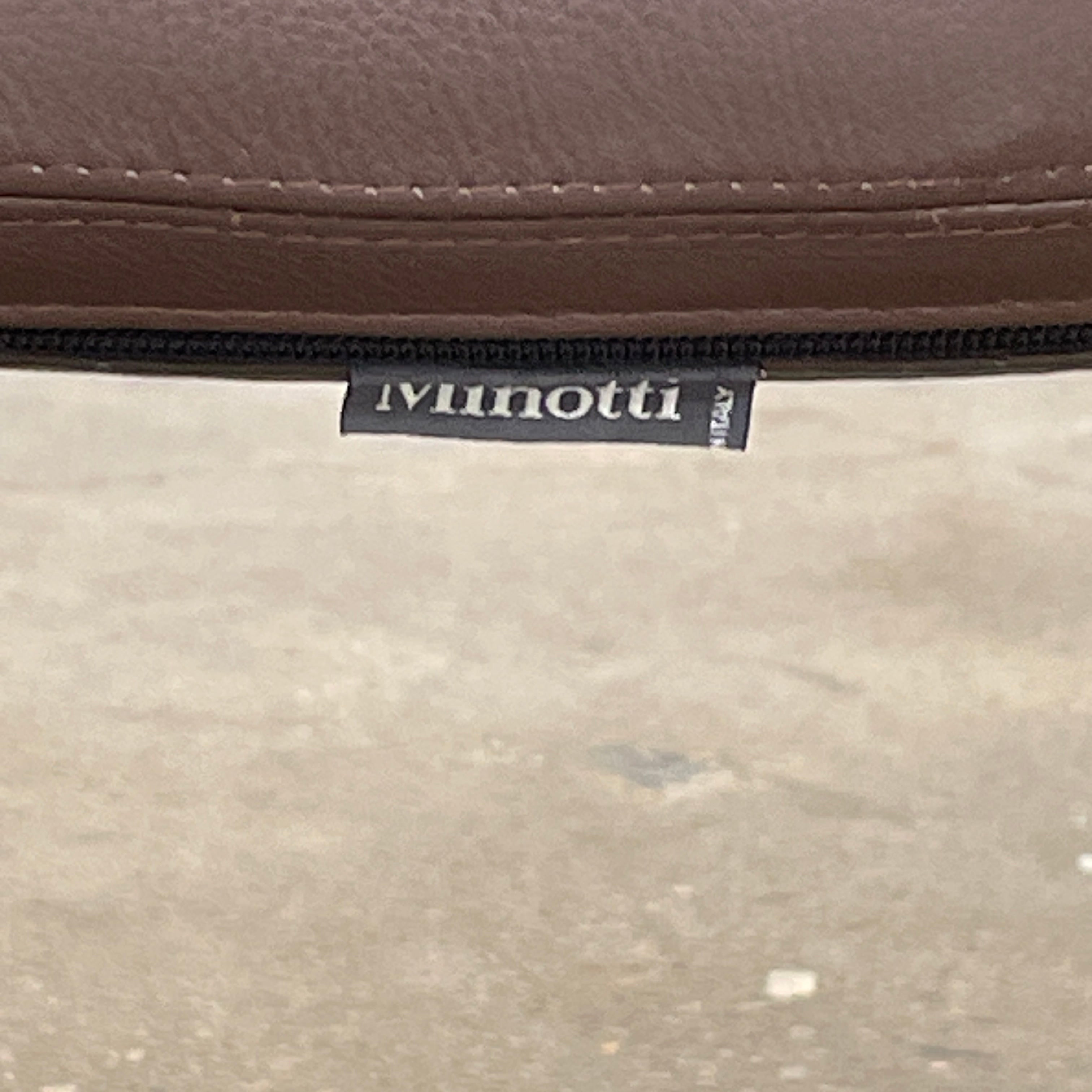 A set of six Minotti Mills Dining Chairs, featuring Scandinavian design with brown leather upholstery and black metal legs, is arranged in a staggered formation against a plain background.