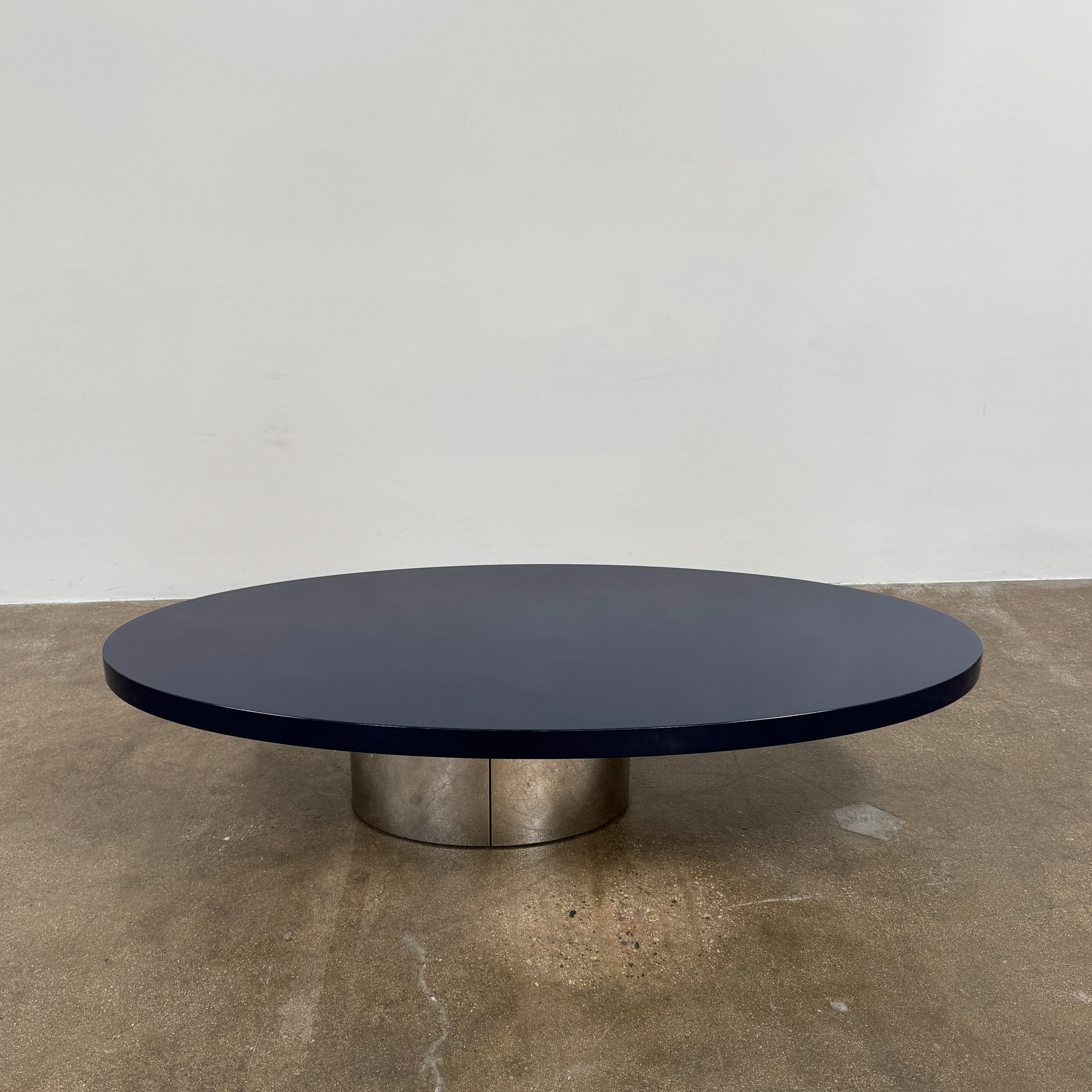 A sleek Minotti Raymond Coffee Table with a metal base, exhibiting clean shapes and proportions.