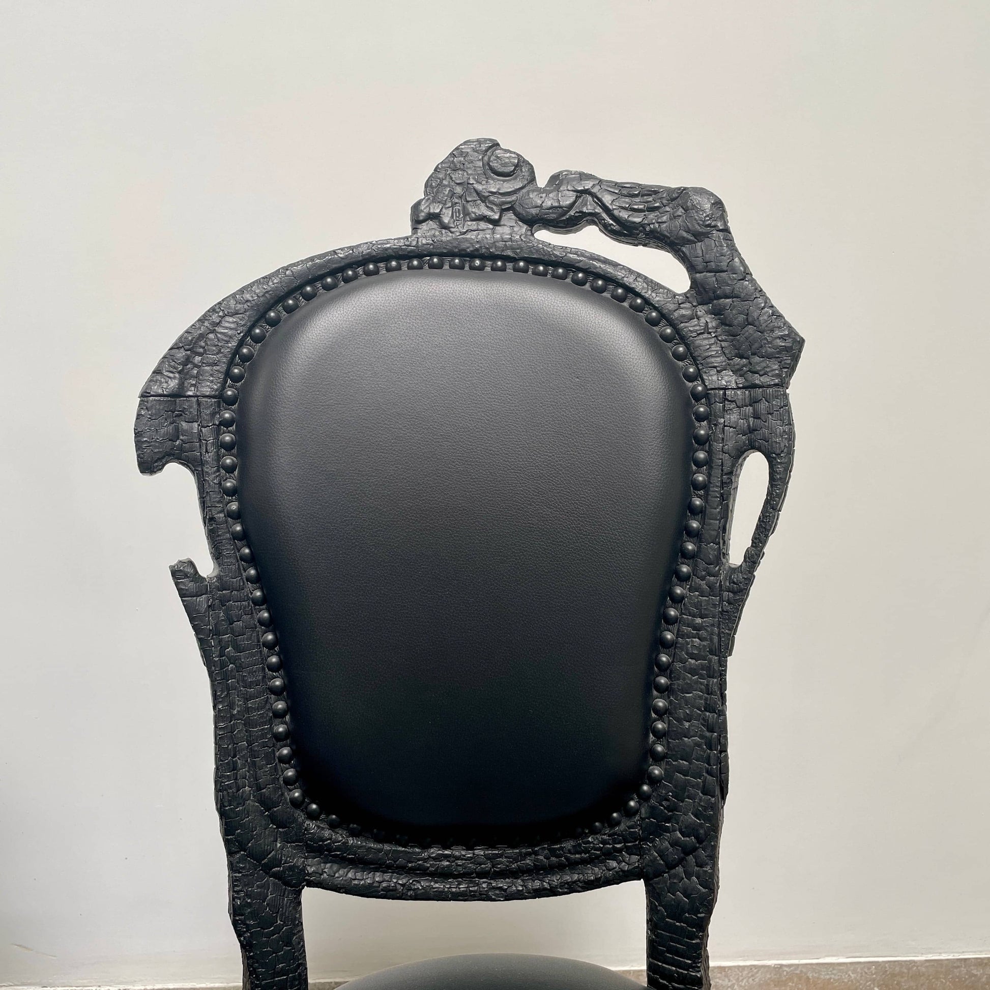 A set of seven Moooi Smoke Dining Side Chairs, crafted by Moooi in an ornate black finish with leather upholstery and cushioned seats and backs, arranged in two rows against a plain white background.