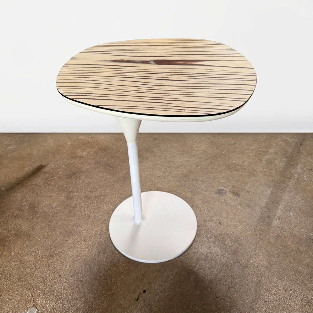 Moroso Bloomy Side Table with an oval, wood-grain top and a single, white pedestal base.