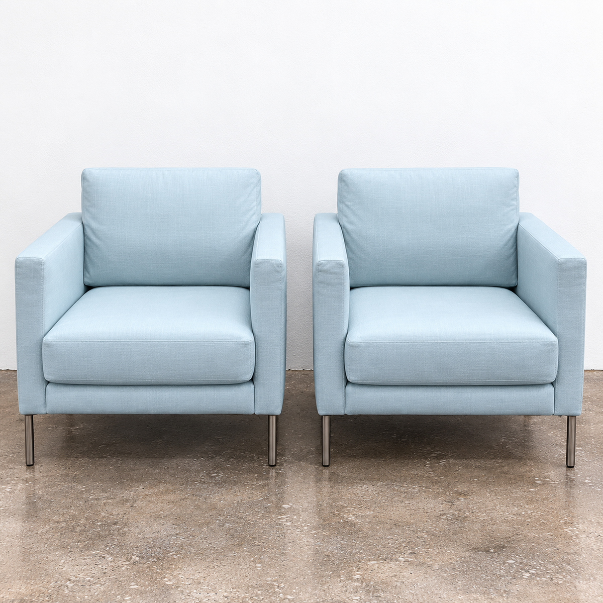 Two light blue Knoll Divina Petite Lounge Chairs with thin metal legs.