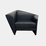 The Lilly of the Wind Armchair by Paolo Pallucco and Mireille Rivier for Pallucco Italia showcases a black leather finish and angular, modern design on a light gray background, echoing Paolo Pallucco's post-modern style.