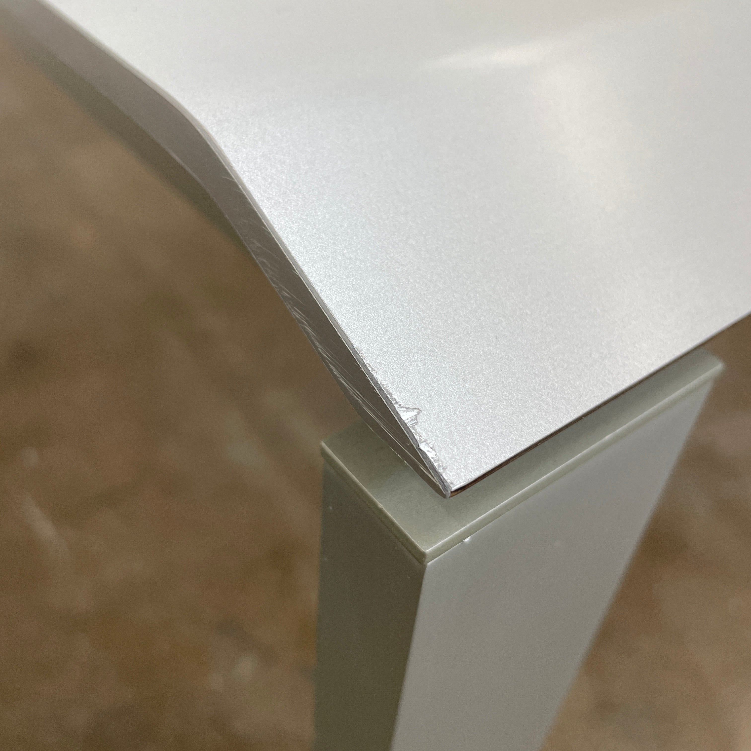 The Pallucco Italia Little Wing Dining Table features a sleek rectangular white top and four straight metal legs—an elegant aluminum dining table by Pallucco Italia, perfect for modern interiors.