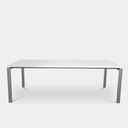 The Pallucco Italia Little Wing Dining Table features a sleek rectangular white top and four straight metal legs—an elegant aluminum dining table by Pallucco Italia, perfect for modern interiors.