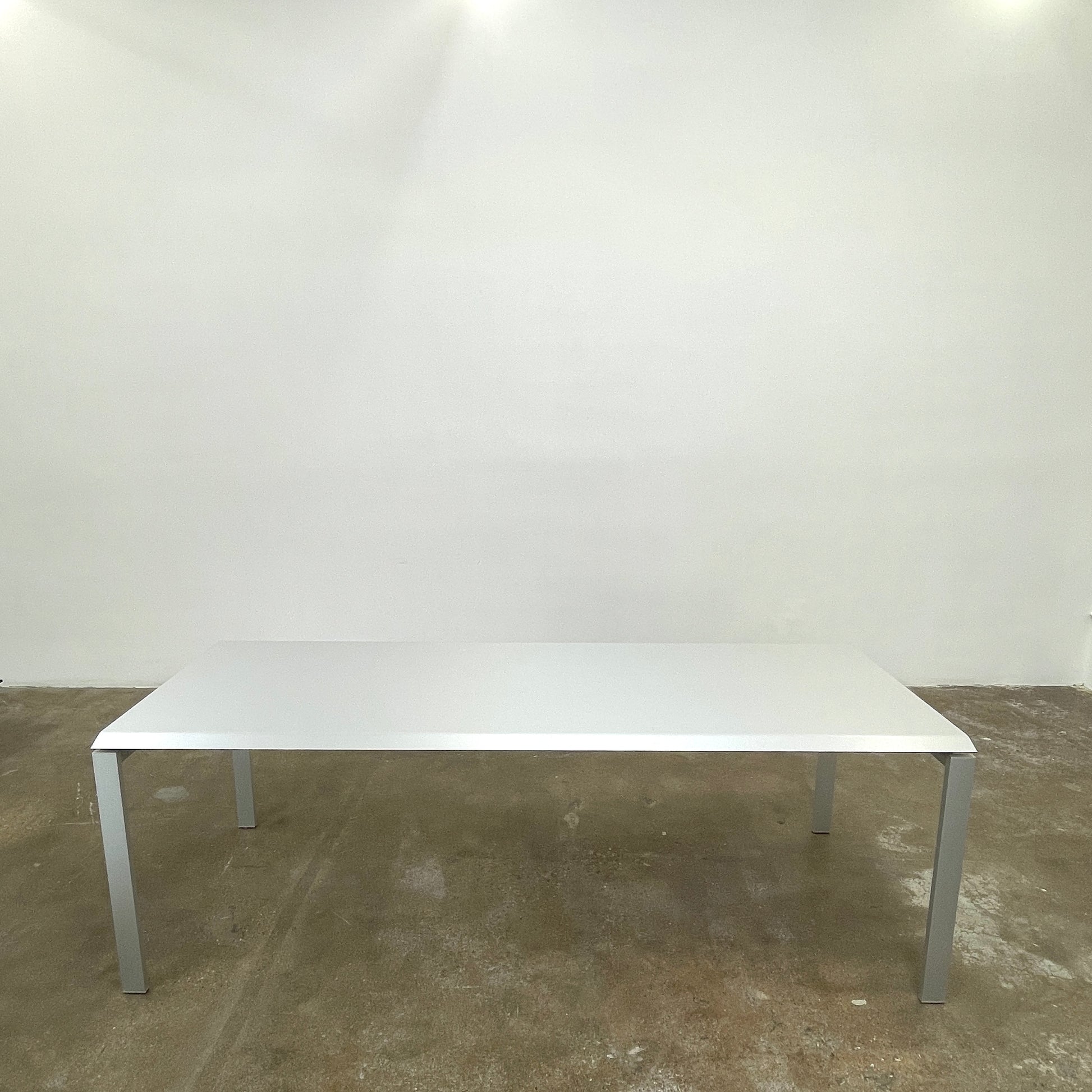 The Pallucco Italia Little Wing Dining Table features a sleek rectangular white top and four straight metal legs—an elegant aluminum dining table by Pallucco Italia, perfect for modern interiors.