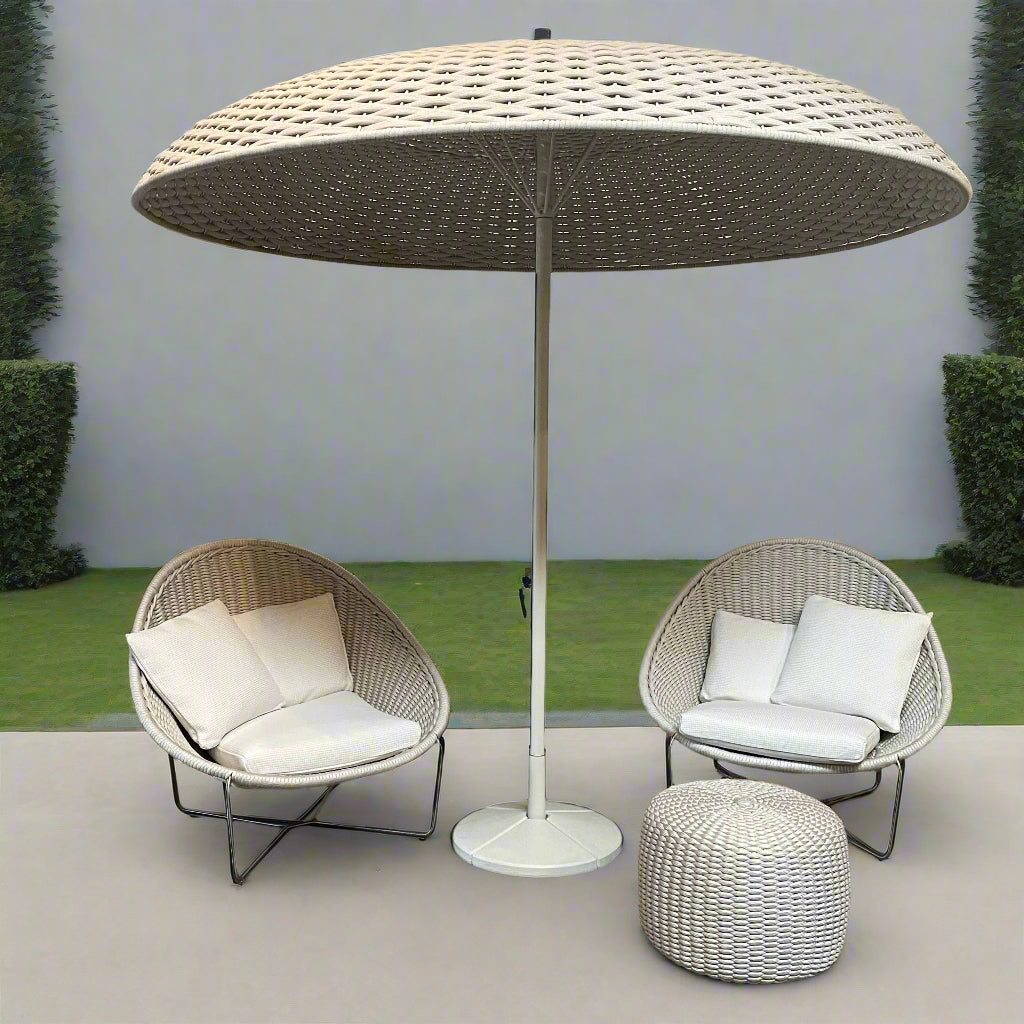 A Paola Lenti Mogambo Parasol on a white stand, designed by Paola Lenti.