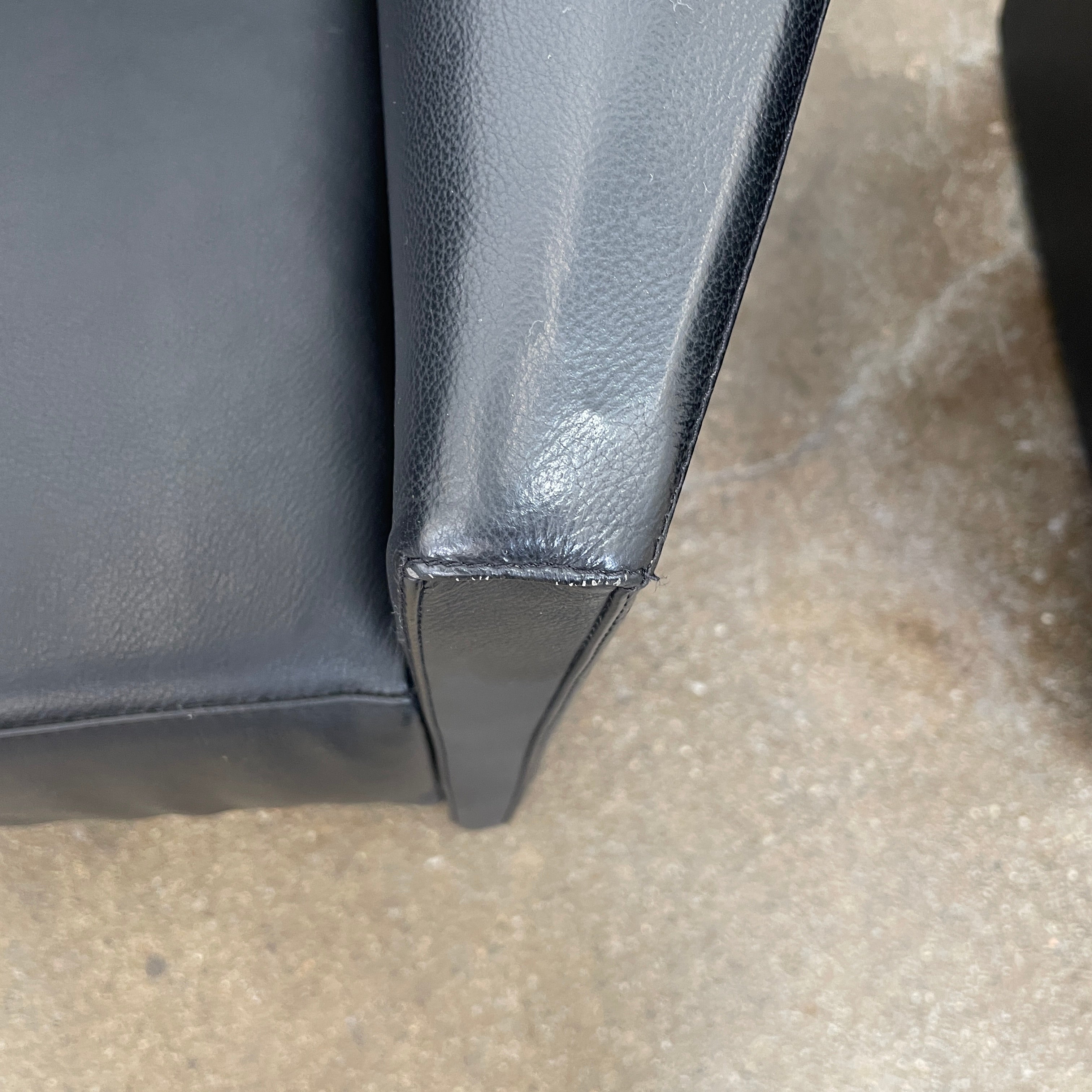 The Lilly of the Wind Armchair by Paolo Pallucco and Mireille Rivier for Pallucco Italia showcases a black leather finish and angular, modern design on a light gray background, echoing Paolo Pallucco's post-modern style.