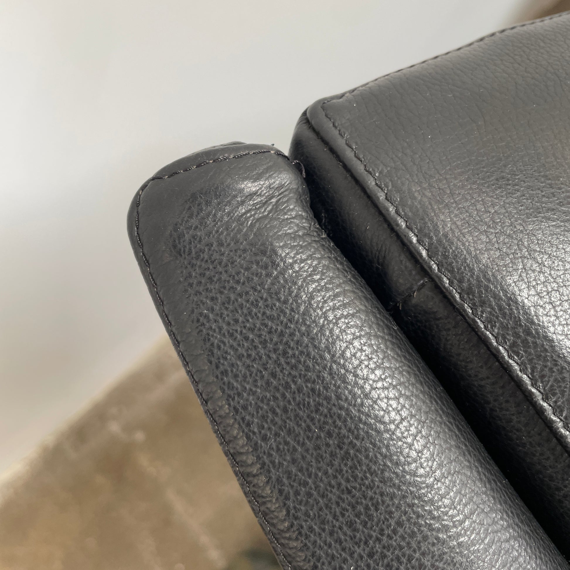 The Lilly of the Wind Armchair by Paolo Pallucco and Mireille Rivier for Pallucco Italia showcases a black leather finish and angular, modern design on a light gray background, echoing Paolo Pallucco's post-modern style.