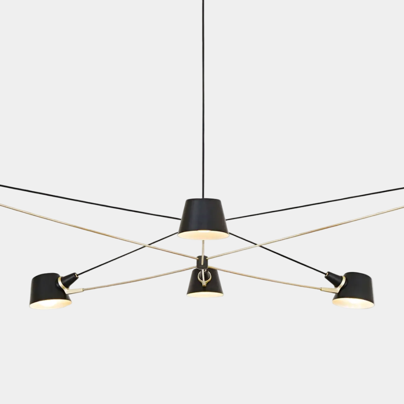 The Pivot chandelier from Ravenhill Studio features six adjustable arms with cone-shaped shades in a modern black finish, suspended against a plain light background to exemplify sculptural lighting characteristic of Ravenhill Studio’s contemporary designs.
