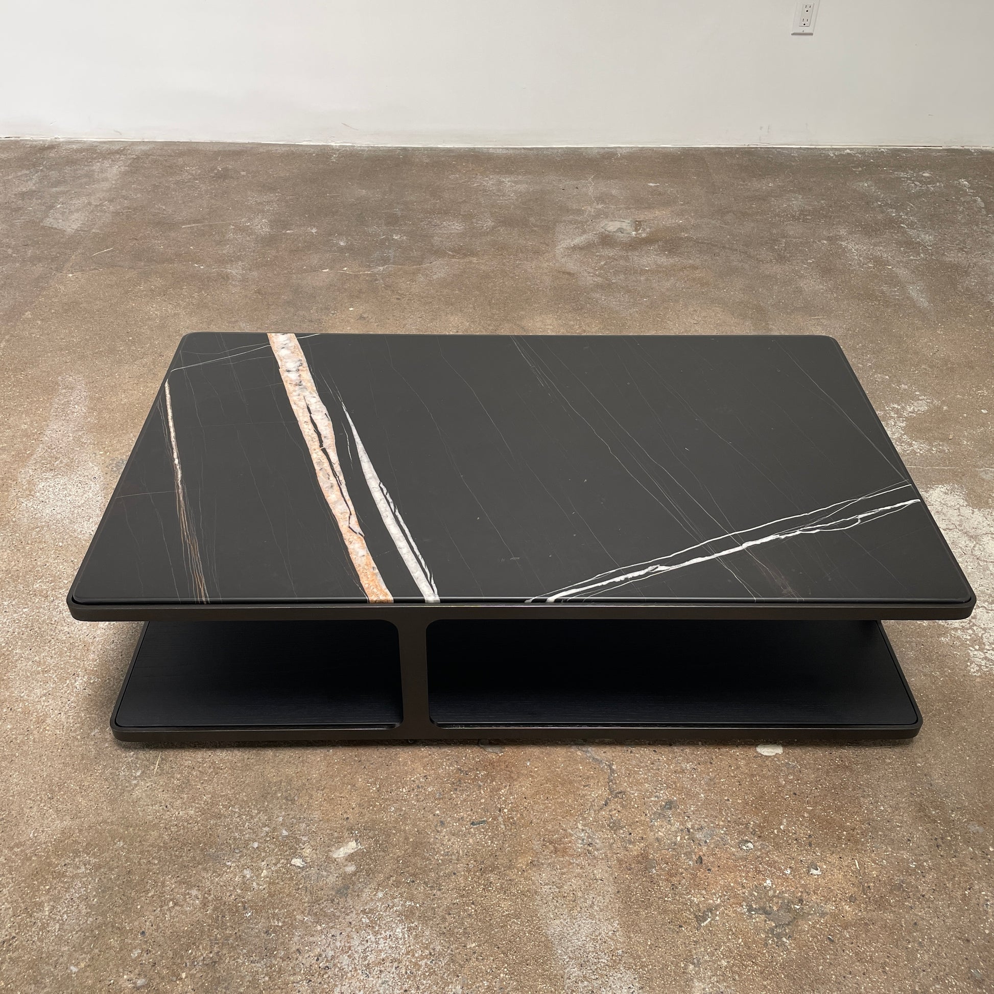 The Poliform Creek Marble Coffee Table is a rectangular Sahara Noir marble piece with a thin, horizontal design and subtle veining.