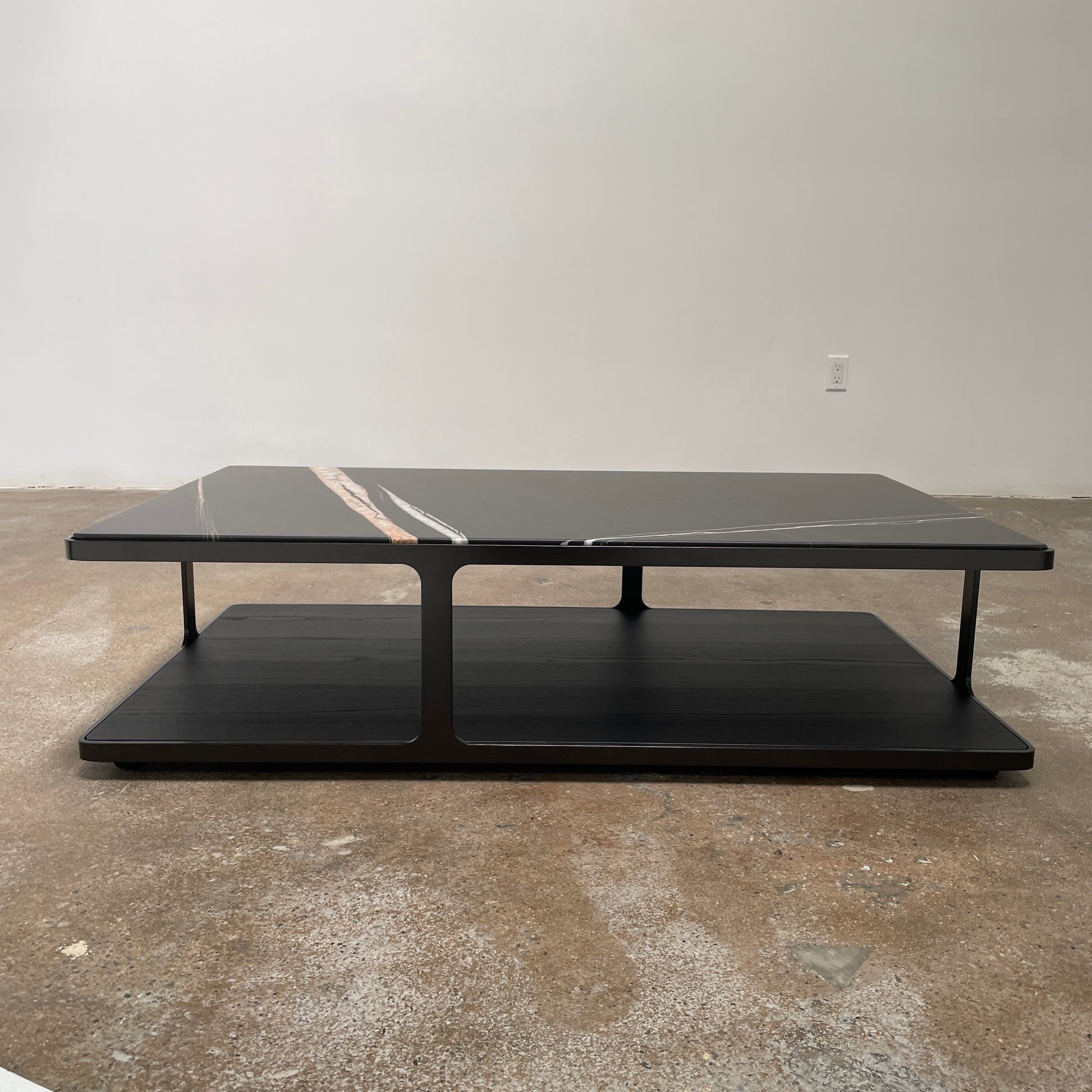 The Poliform Creek Marble Coffee Table is a rectangular Sahara Noir marble piece with a thin, horizontal design and subtle veining.