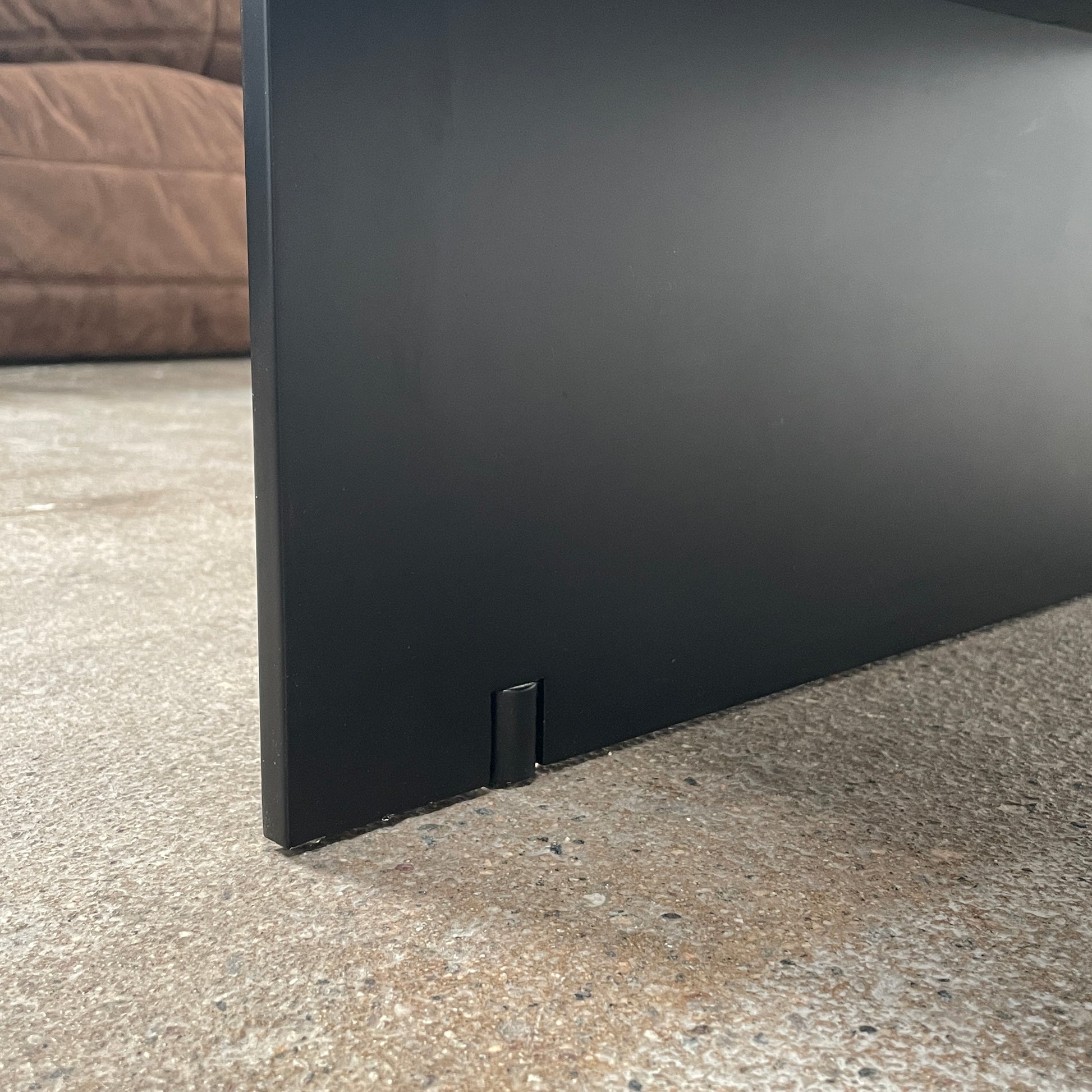 The Porro Modern Light Low Table by Piero Lissoni showcases a minimalist black design with a sleek metal structure and simple, rectangular legs, set against a plain background.