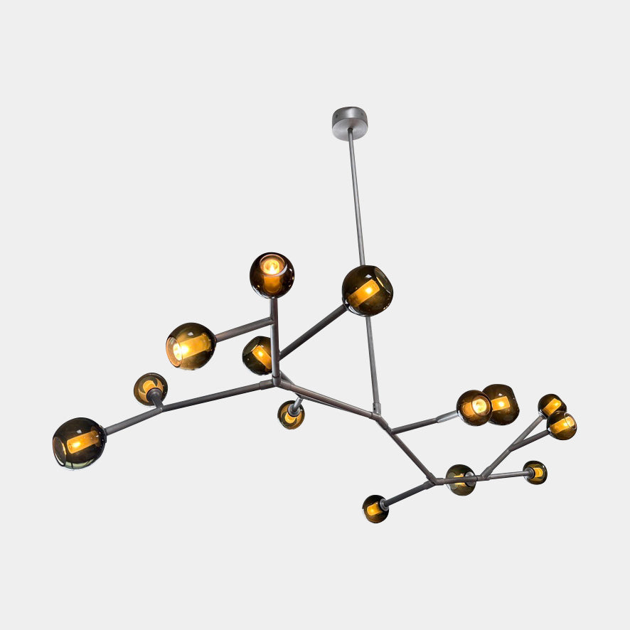 The Pouenat Last Night Branche Chandelier by Pouenat, featuring mouth-blown glass spheres, hangs beneath a white exposed beam ceiling with visible ductwork—an ideal statement for modern industrial interiors.