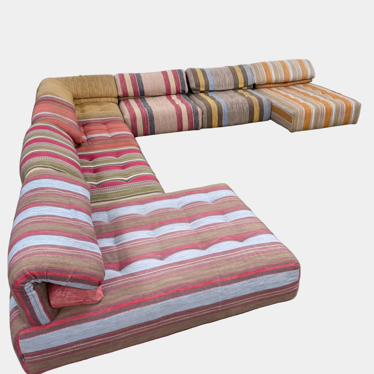 An L-shaped Roche Bobois Voyage Immobile Seven Piece Sectional sofa upholstered in various striped fabric patterns.
