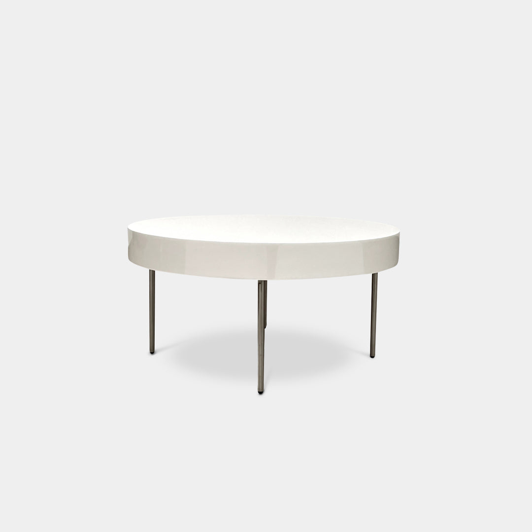 The Ligne Roset White Lacquer Needle Table features a sleek lacquer top and four slender metal legs, perfectly exemplifying modern minimalism against a plain background.