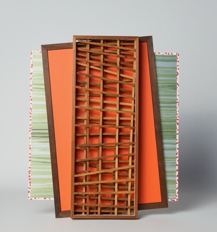 Three rectangular trays—one with green stripes, one orange, and one wooden tray with a lattice design—overlap to form the “Multi Media Wall Art: by Mike Fair” by Artist, evoking the dynamic, layered style characteristic of Mike Fair’s signature 3D wall pieces.