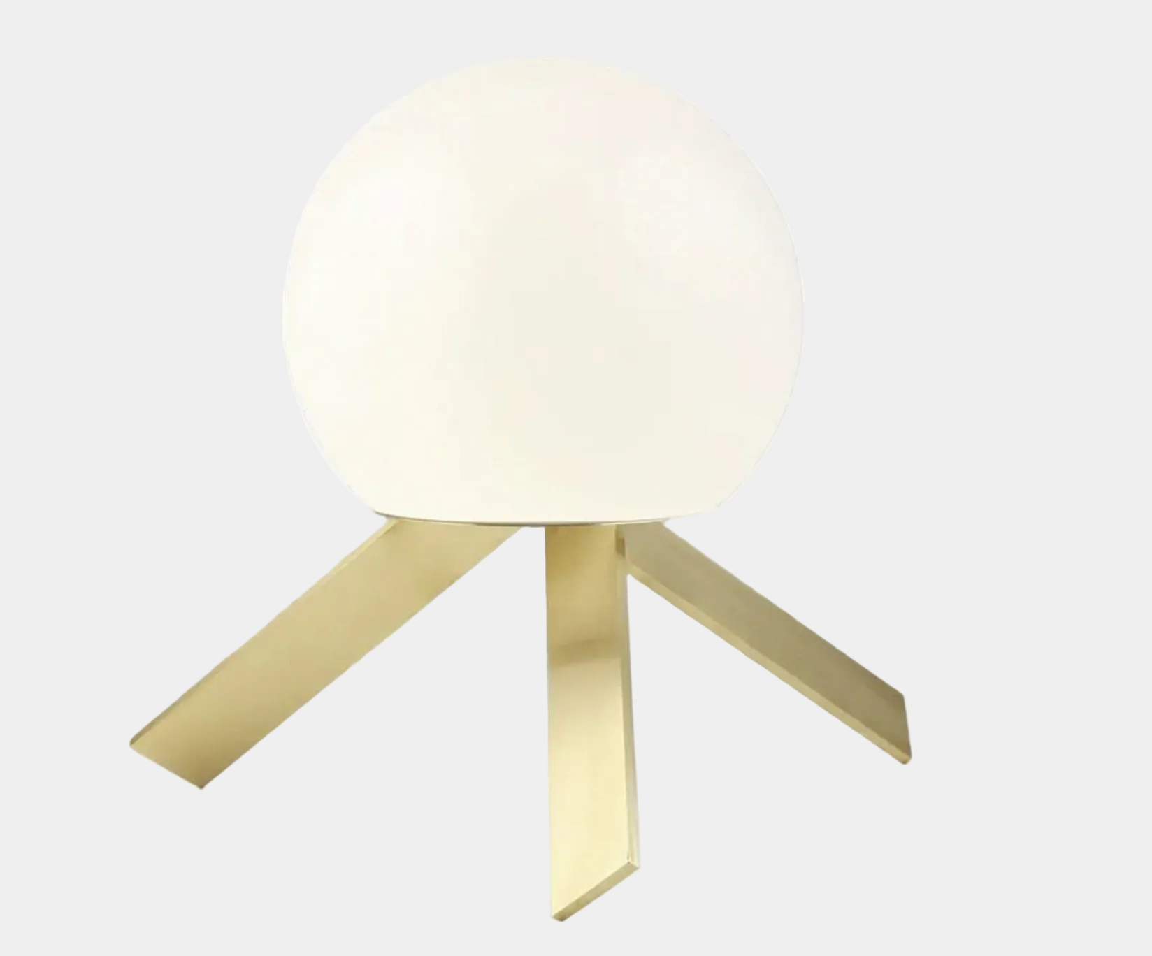 The Michael Anastassiades To The Top Table Lamp features a spherical white opaline glass shade and sits on three gold angled legs, designed by Michael Anastassiades, set against a plain light background.