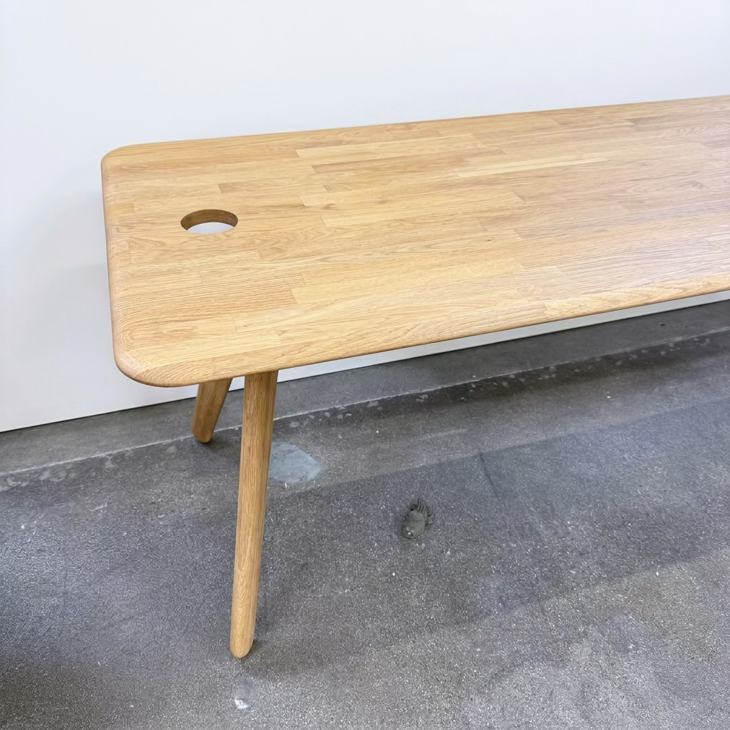 A rectangular solid oak Tom Dixon Slab Desk/Table with cord management, featuring four angled legs and two circular cable management ports on the surface.